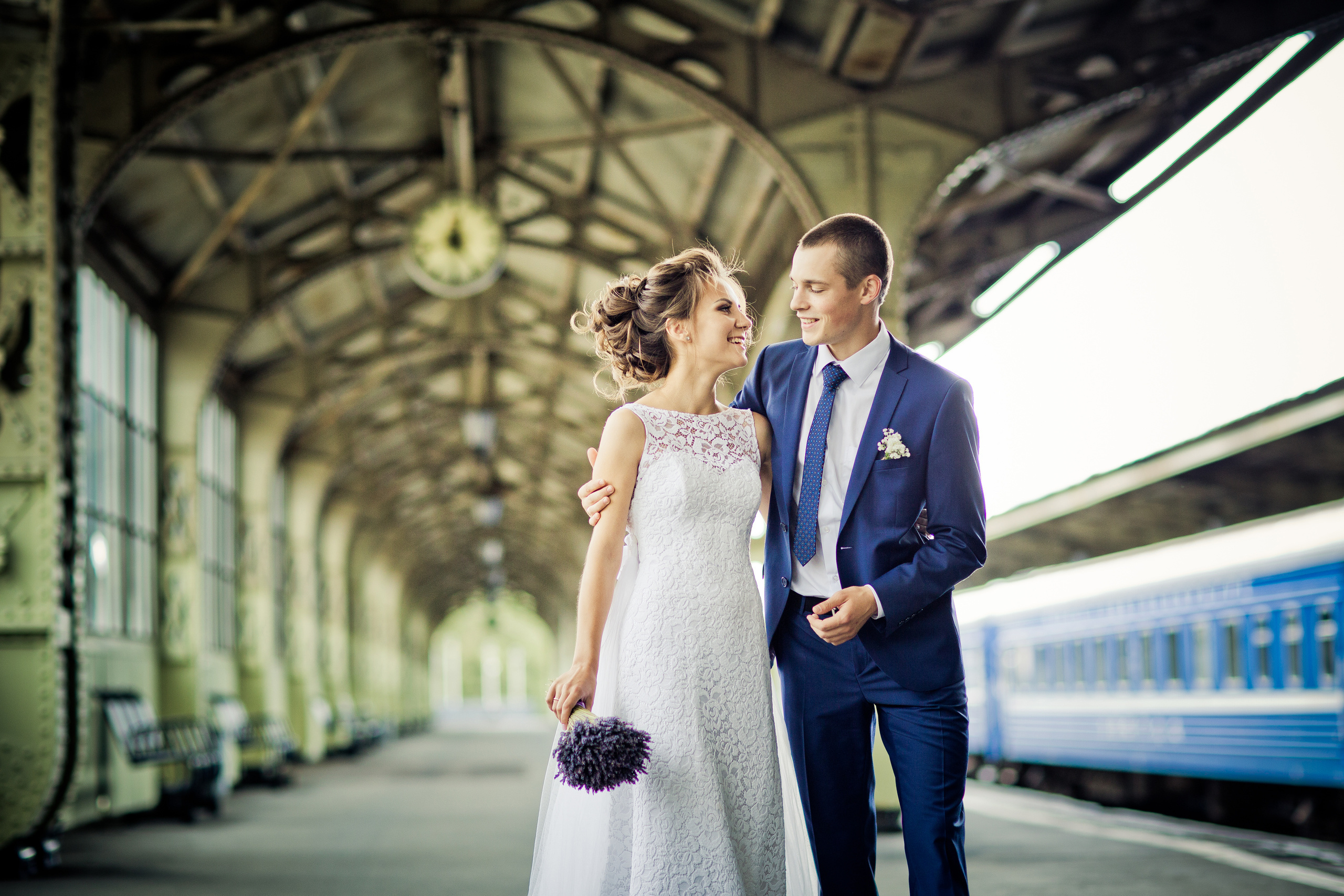 жених и невеста с букетом идут обнявшись по платформе Витебского вокзала