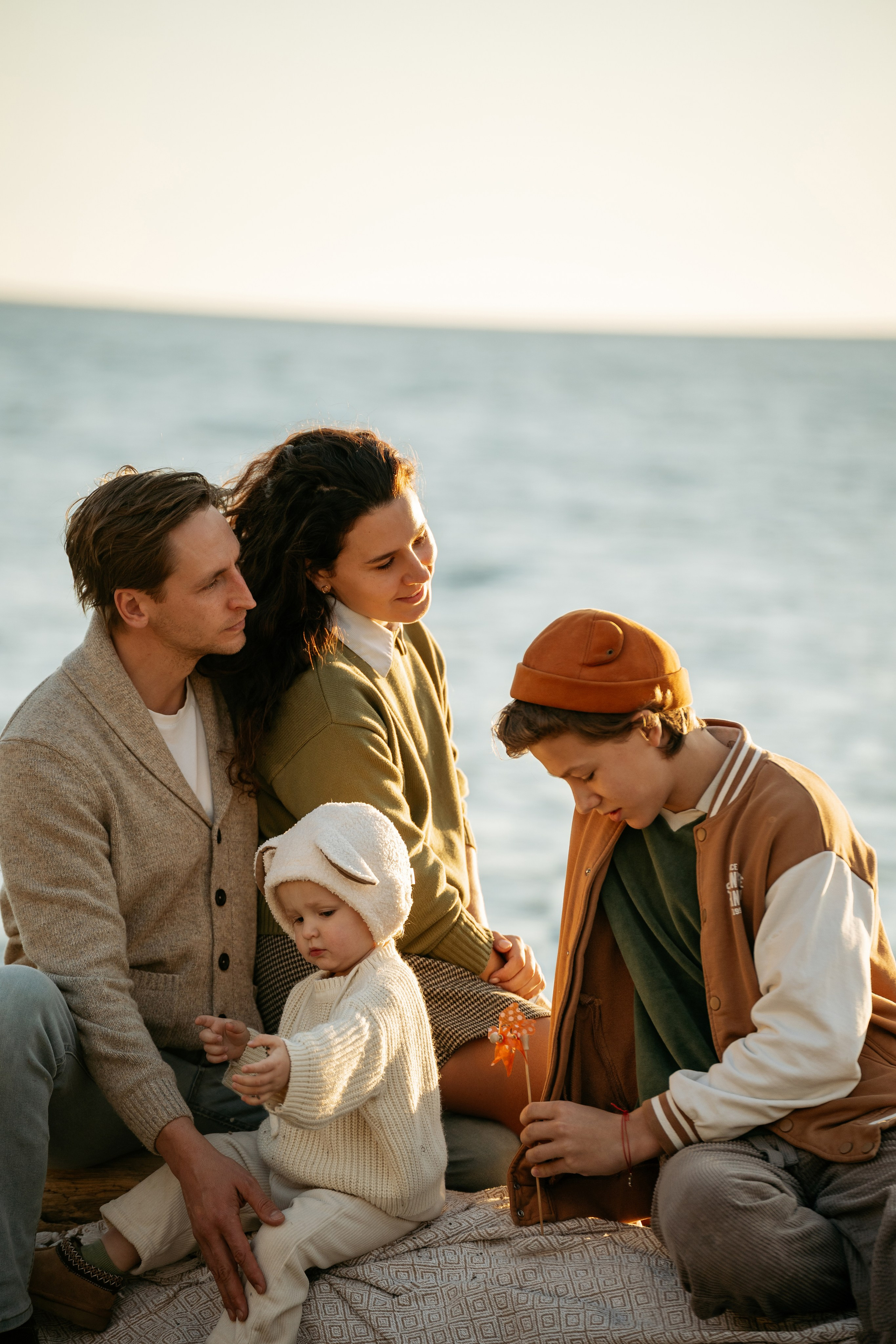 Фотосессия семьи на побережье Новороссийска. Счастливые мама, папа, маленькая дочка и сын-подросток на фоне Черного моря. Фотограф Новороссийск.