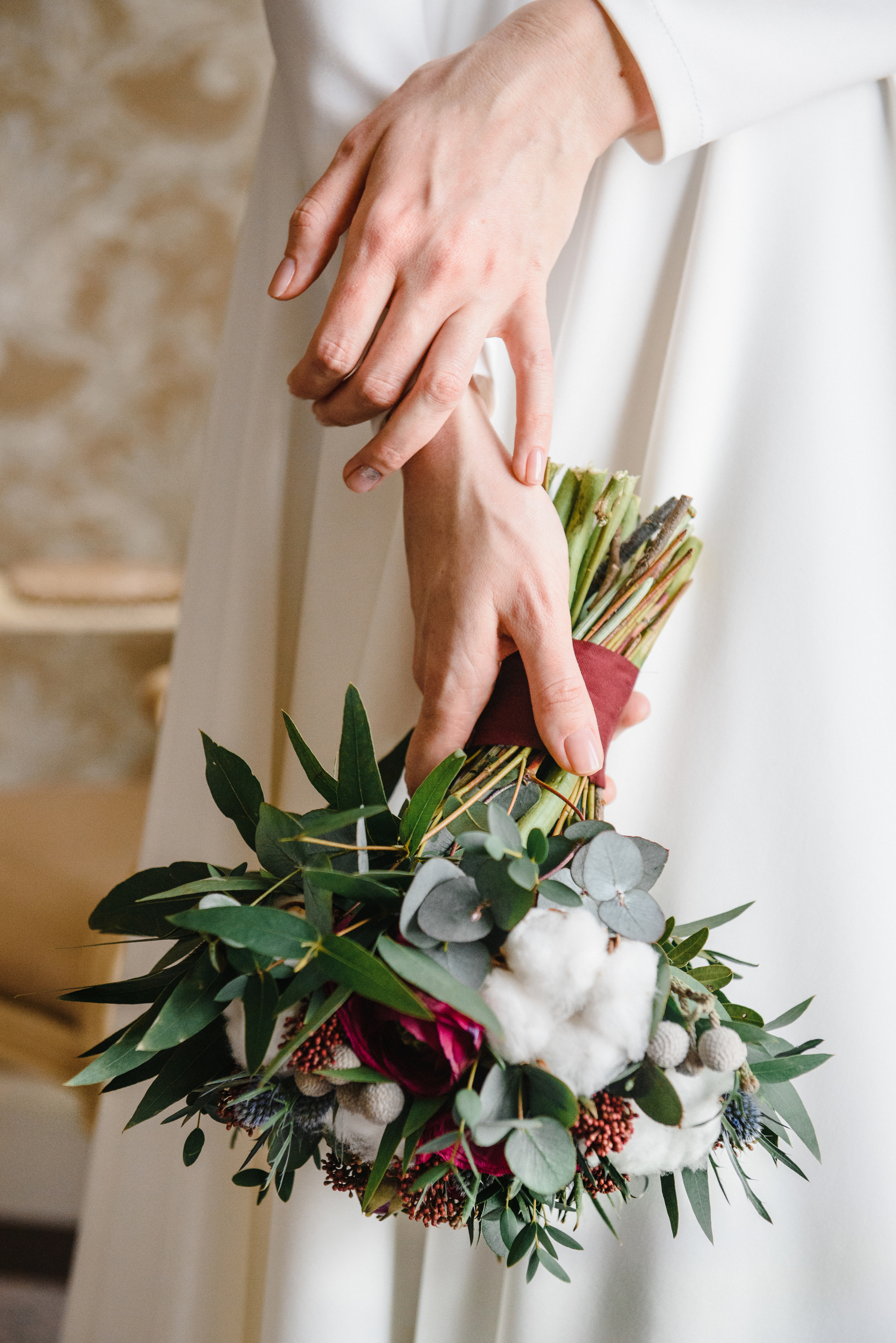 Руки девушки в белом платье с букетом