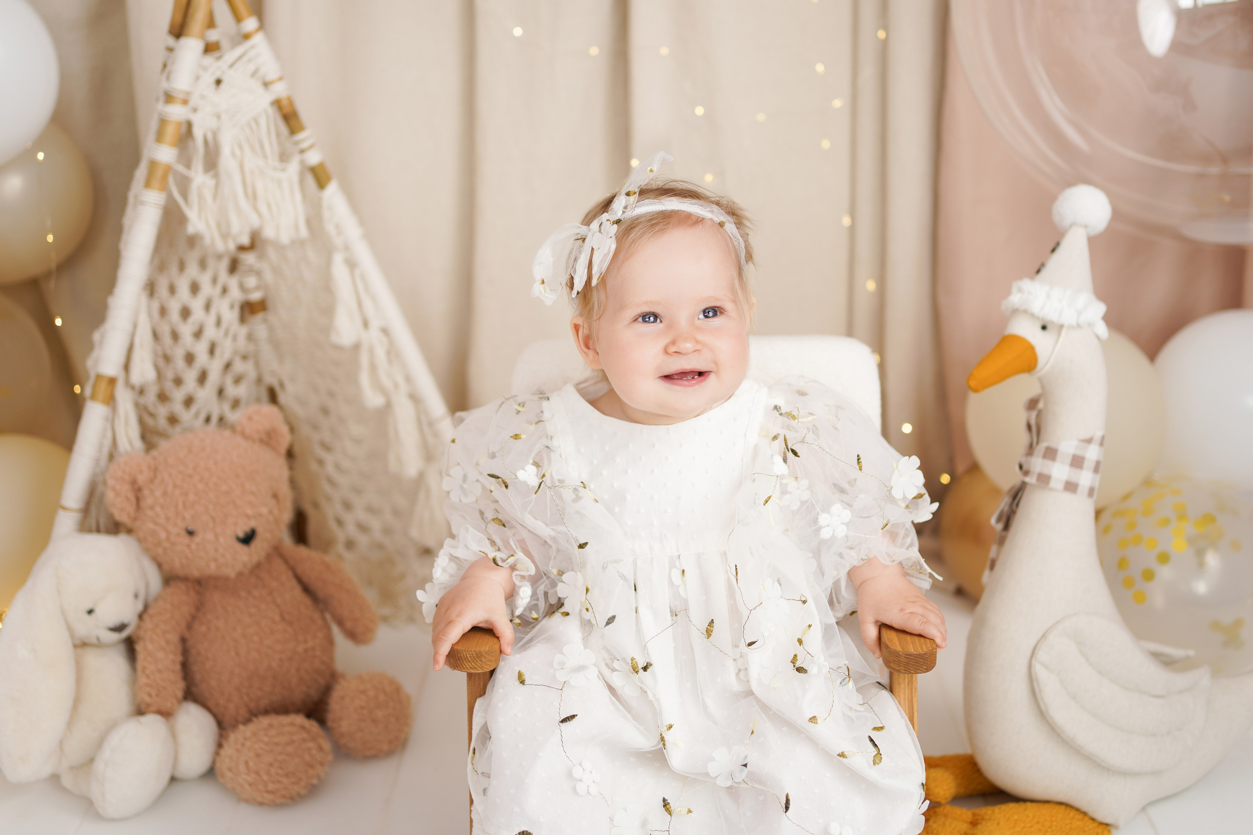 На фото малышка рядом с игрушками, красивыми шариками на фотосессии Первый год. 