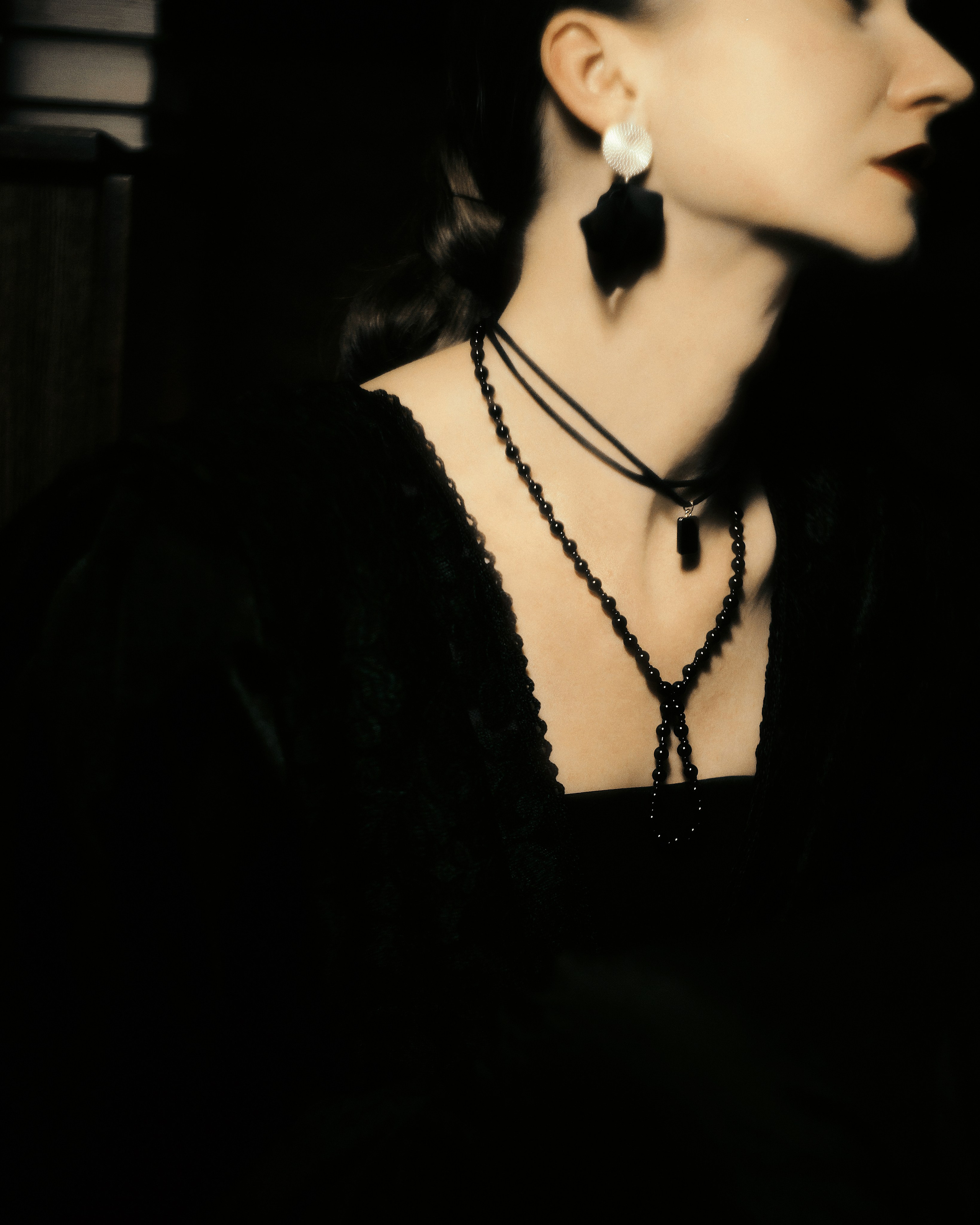 деталь женского портрета: роскошная шея, чёрное платье, кулон и серьги, студийная нуар фотосессия, фотограф СПб