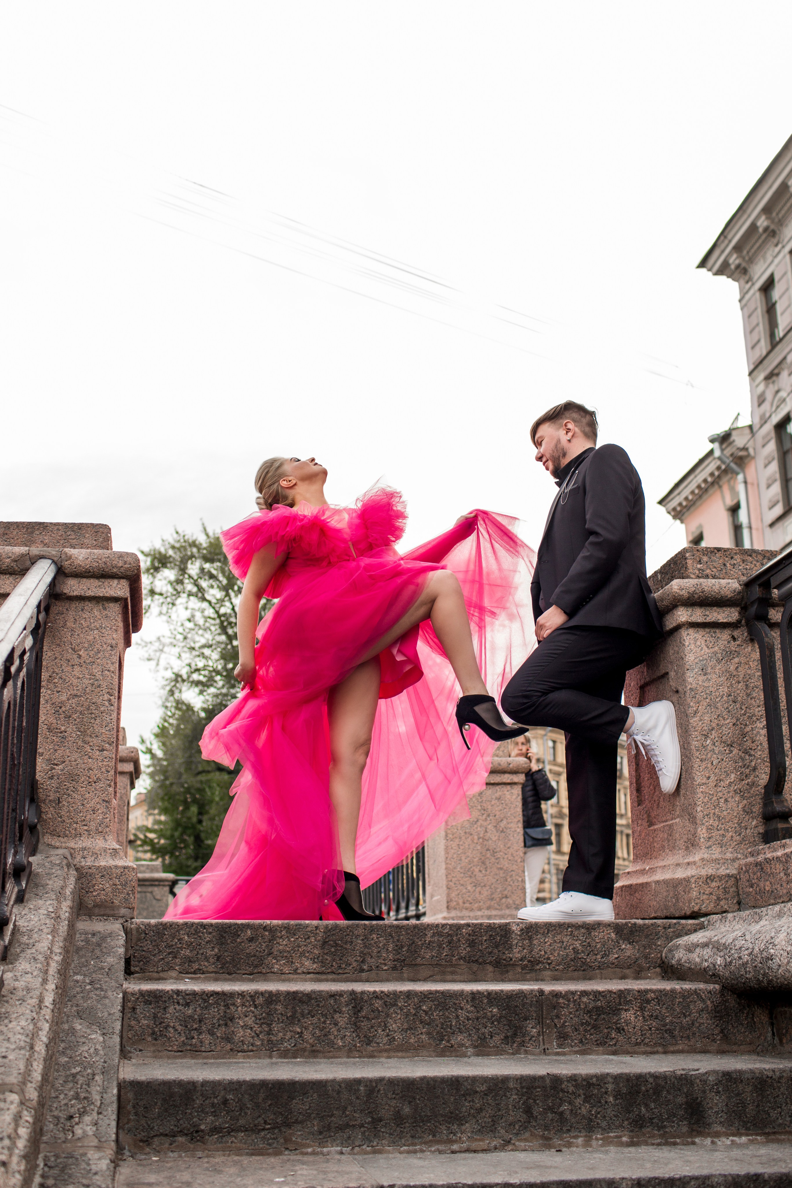 Романтический момент с невестой в алом платье на фоне архитектуры Санкт-Петербурга