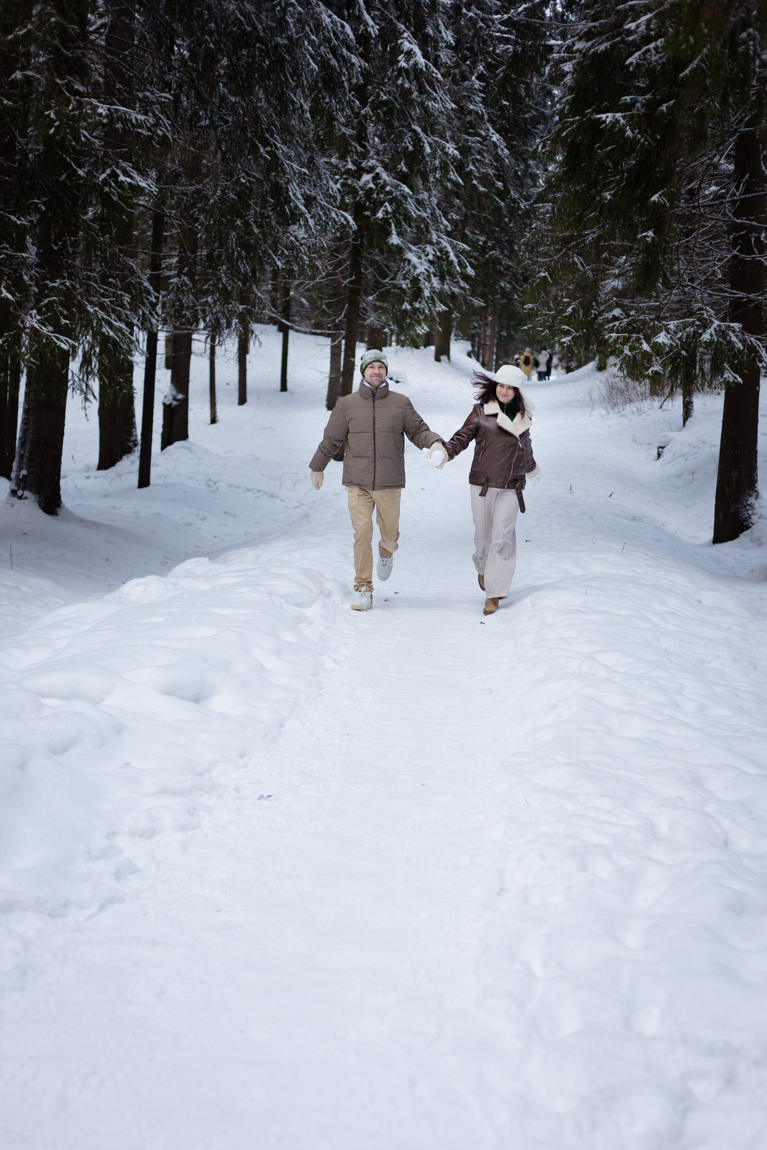 бегущая влюбленная пара в зимнем парке
