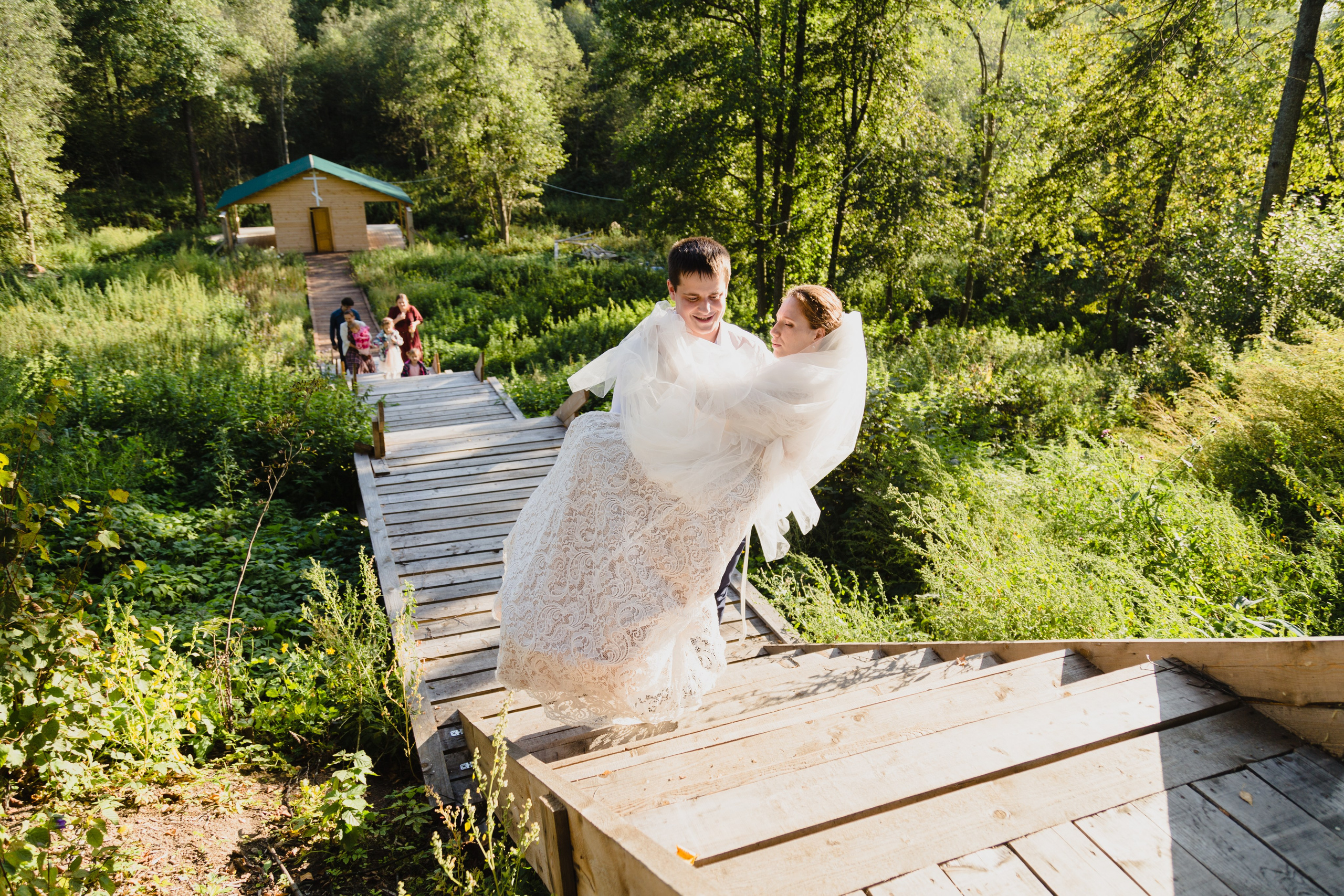 жених несет невесту на руках, свадебный кадр