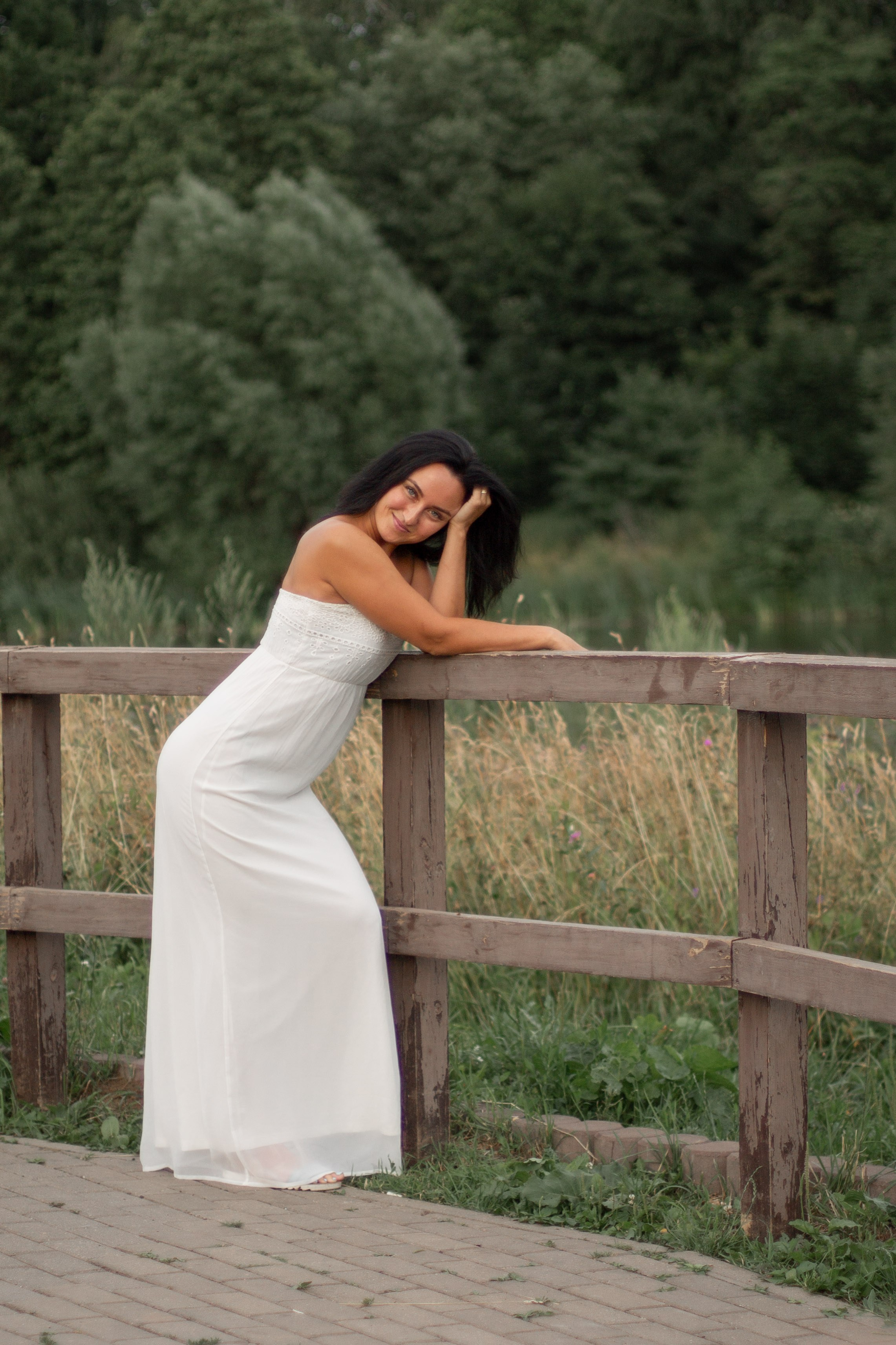 Фотография девушки в белом платье на набережной реки