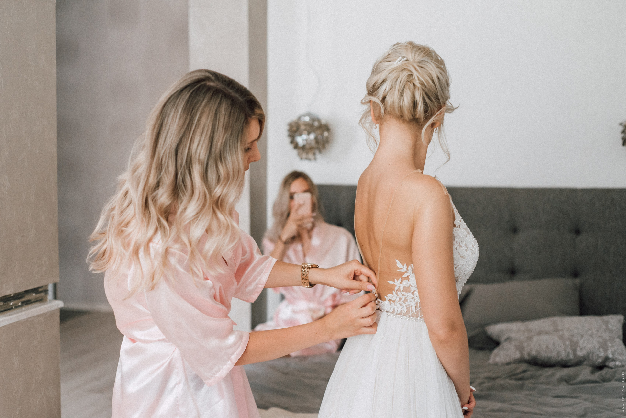 Подружки невесты помогают надевать платье