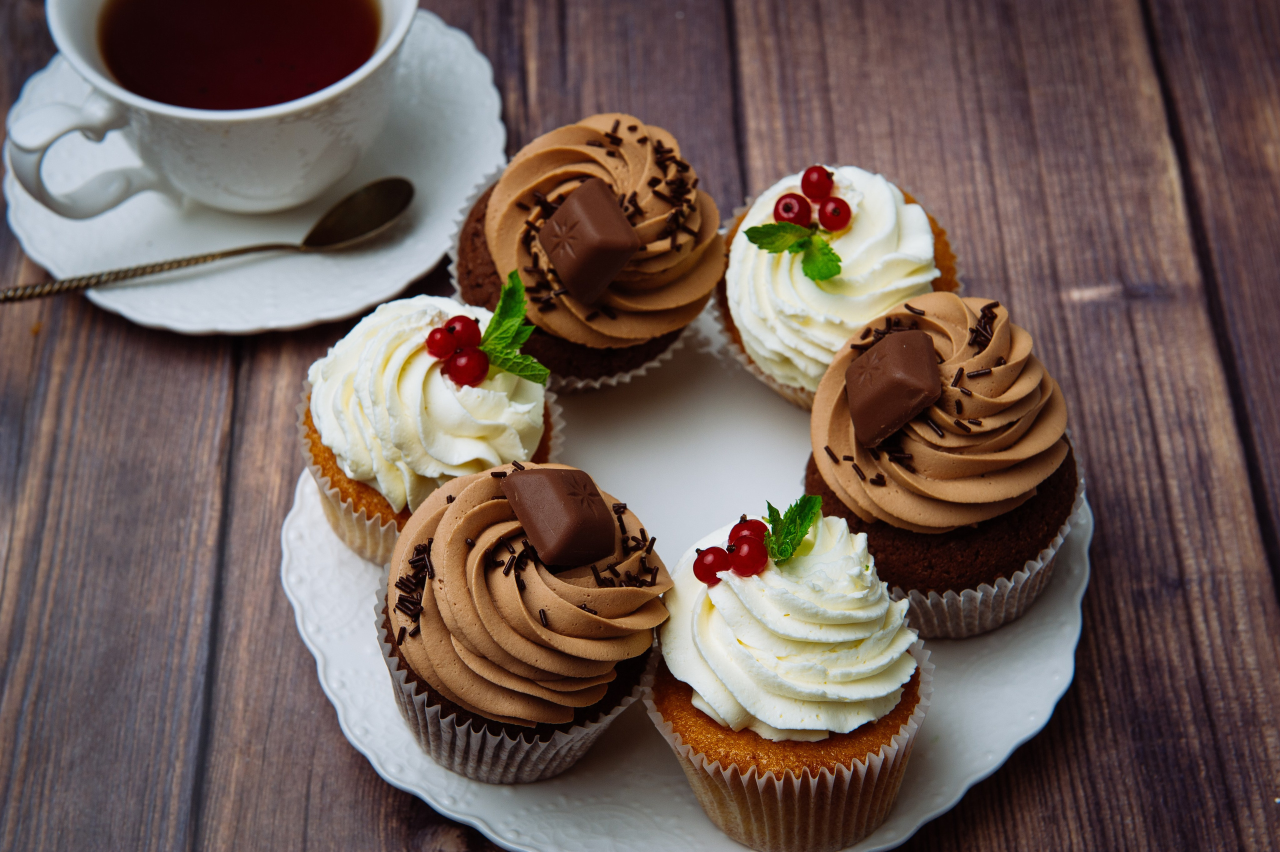 Пирожные капкейки и чай, акцент на текстурах и цветах, вид сверху.