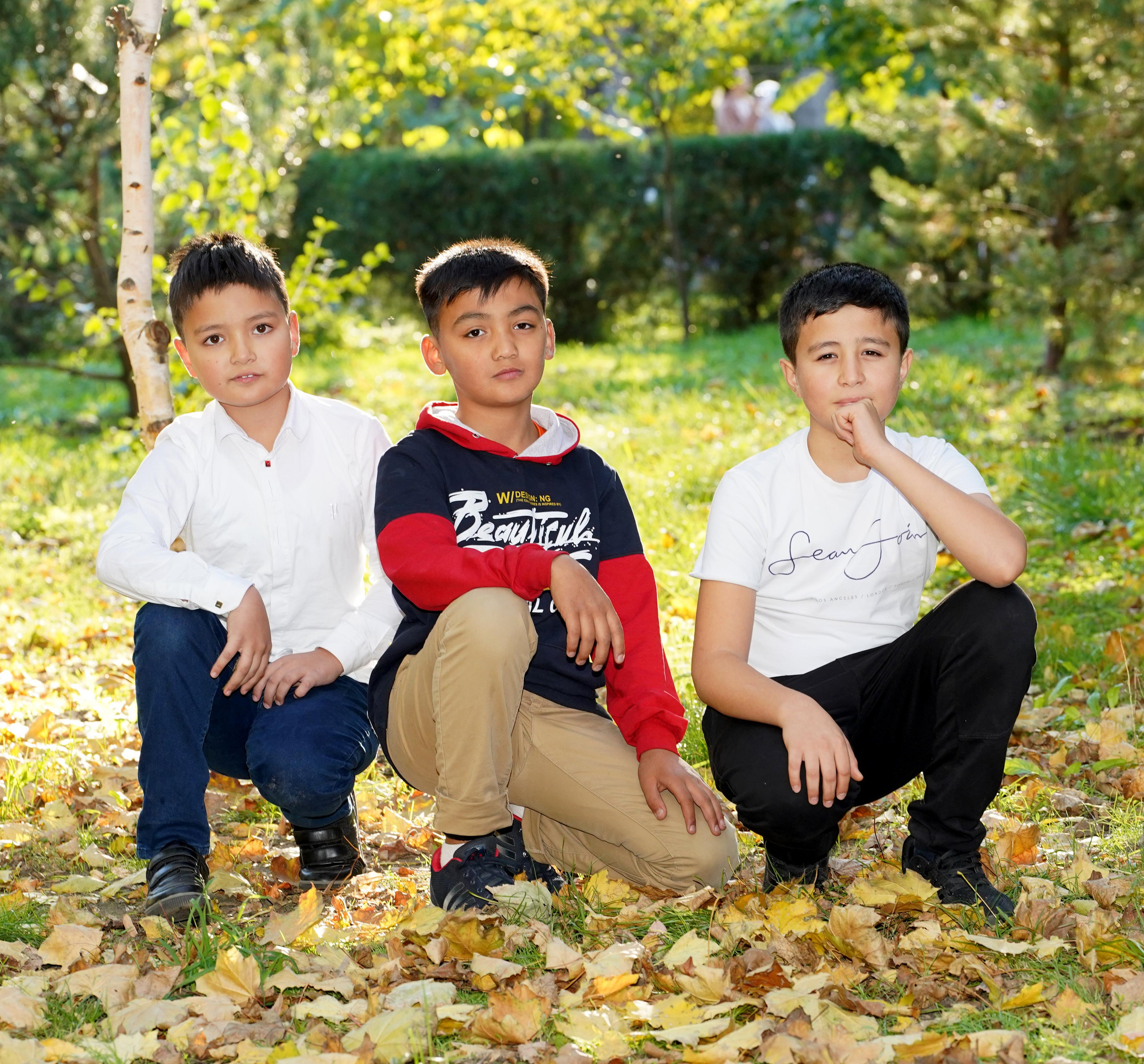 мальчики в парке на осеннем фоне с листьями