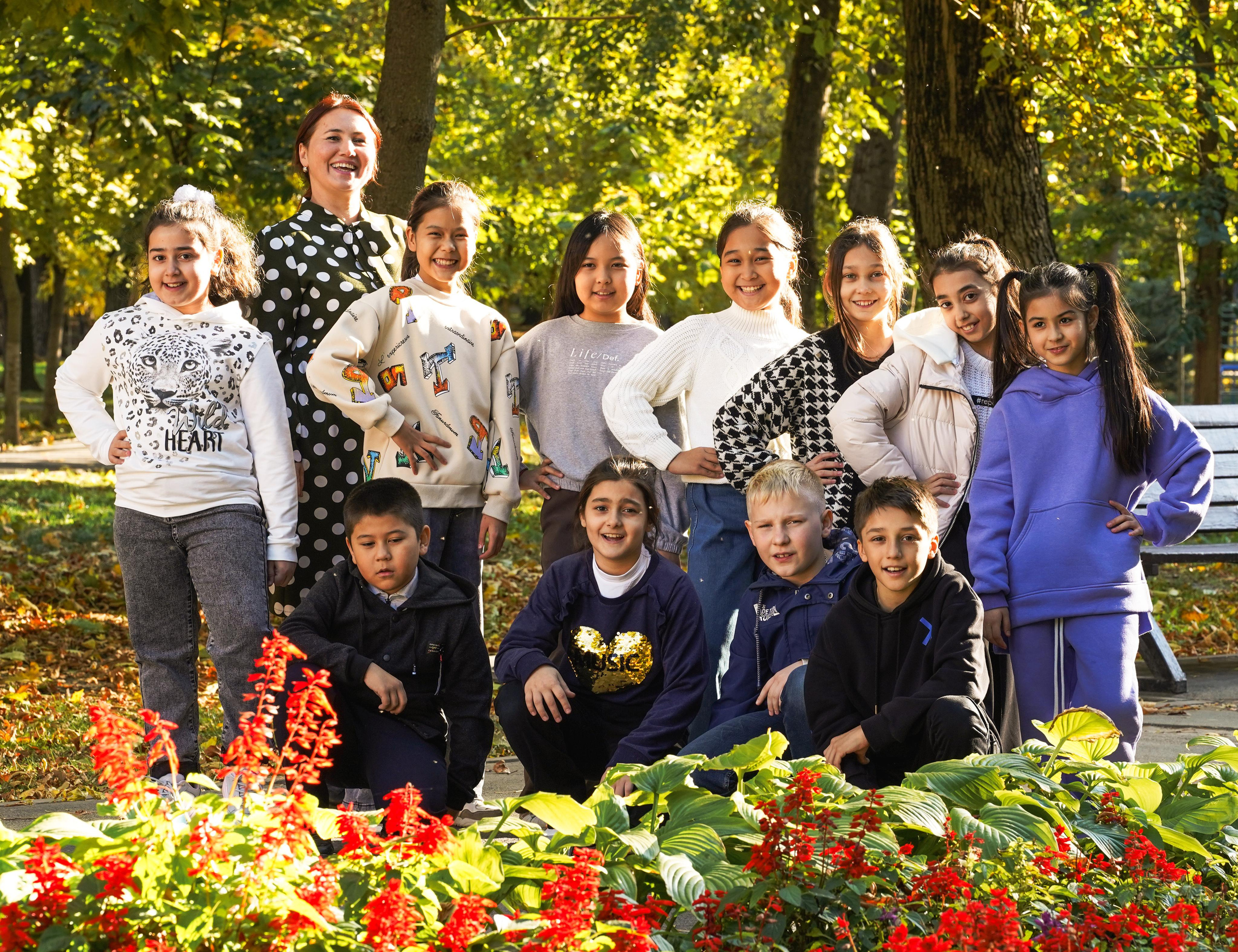 класс и учитель на фоне цветов в парке