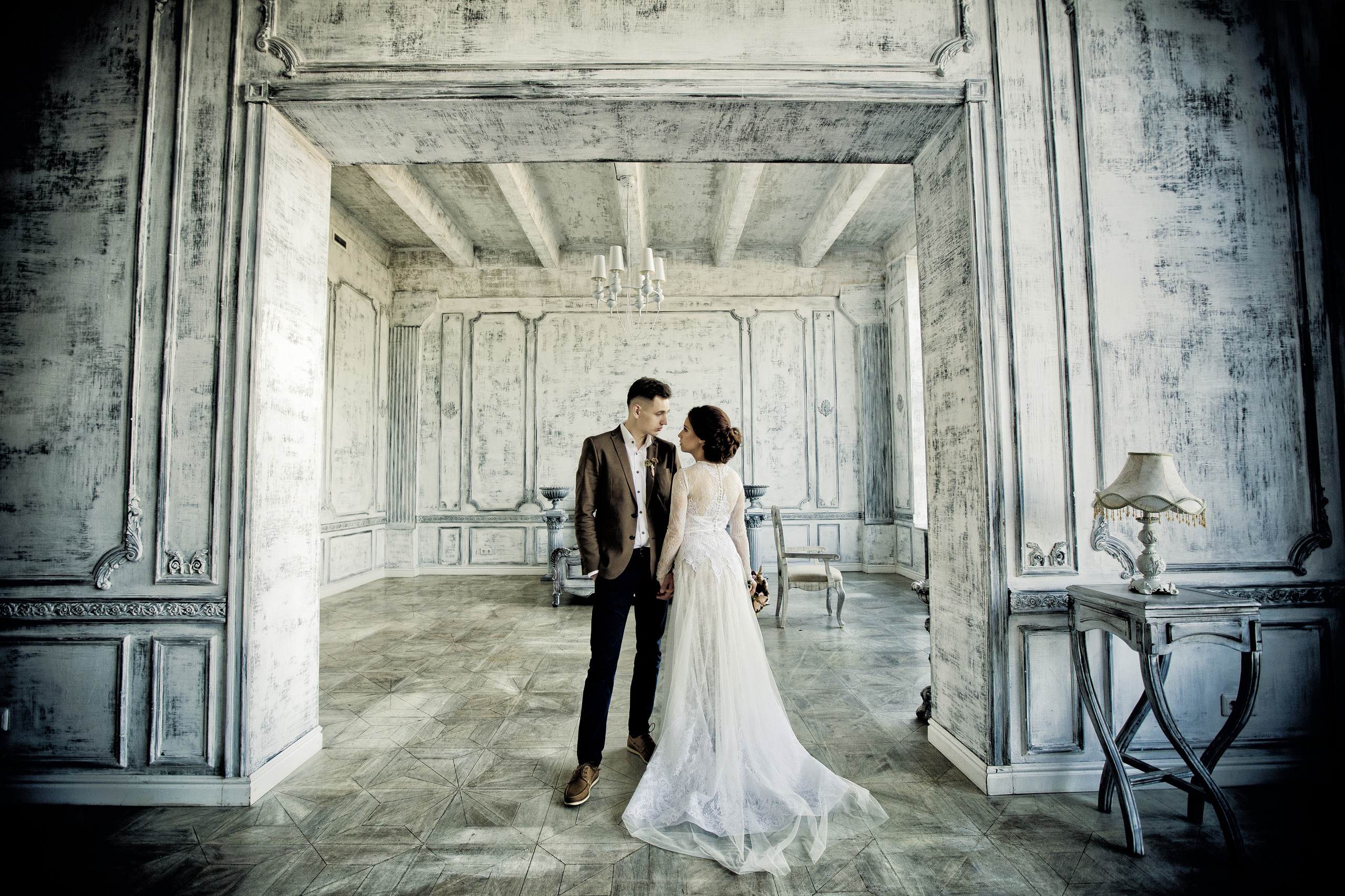 жених и невеста стоят на паркете старинного особняка со светлой отделкой