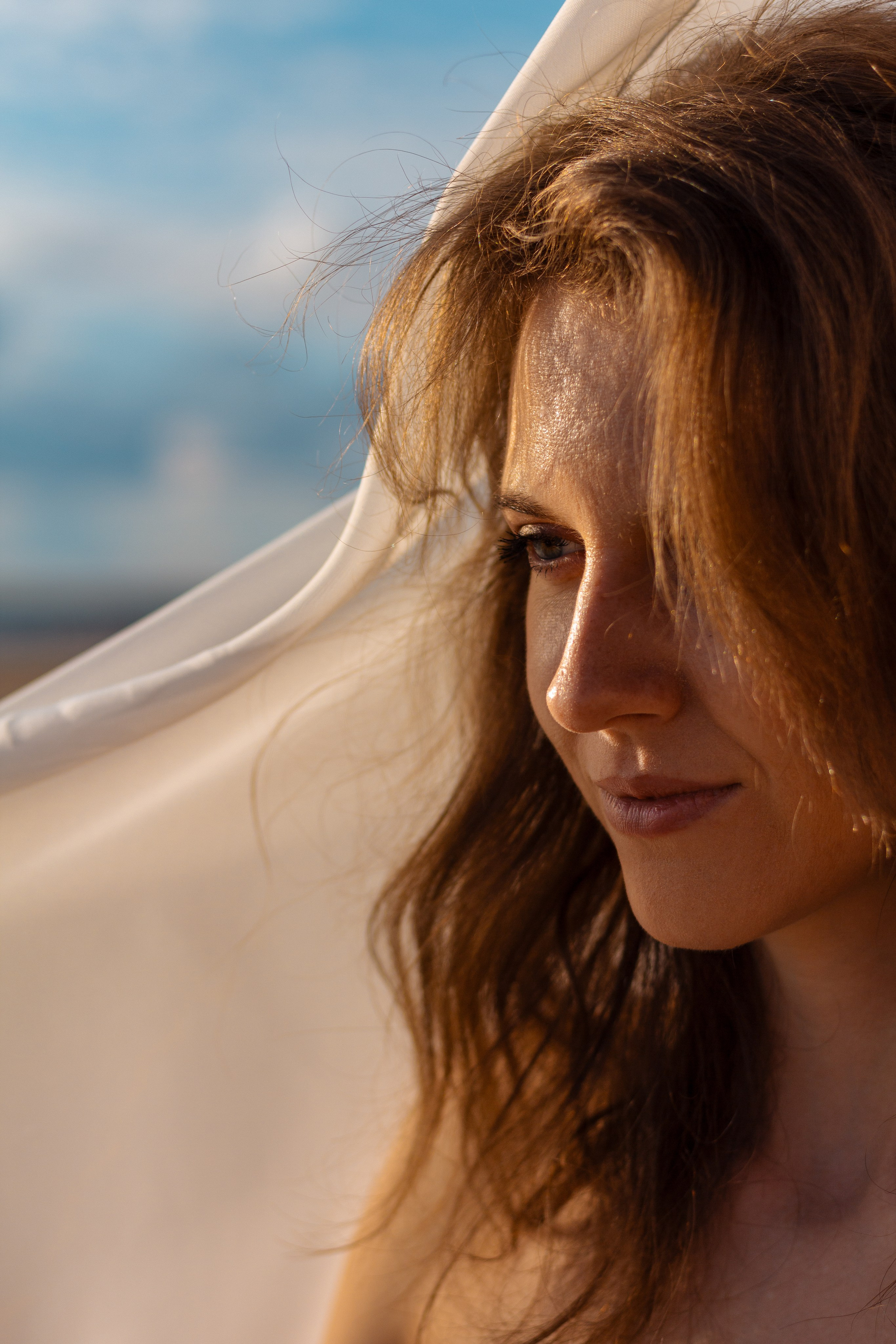 Красивая девушка с задумчивым взглядом. Девушка под белой воздушной тканью. Фотосессия СПб.