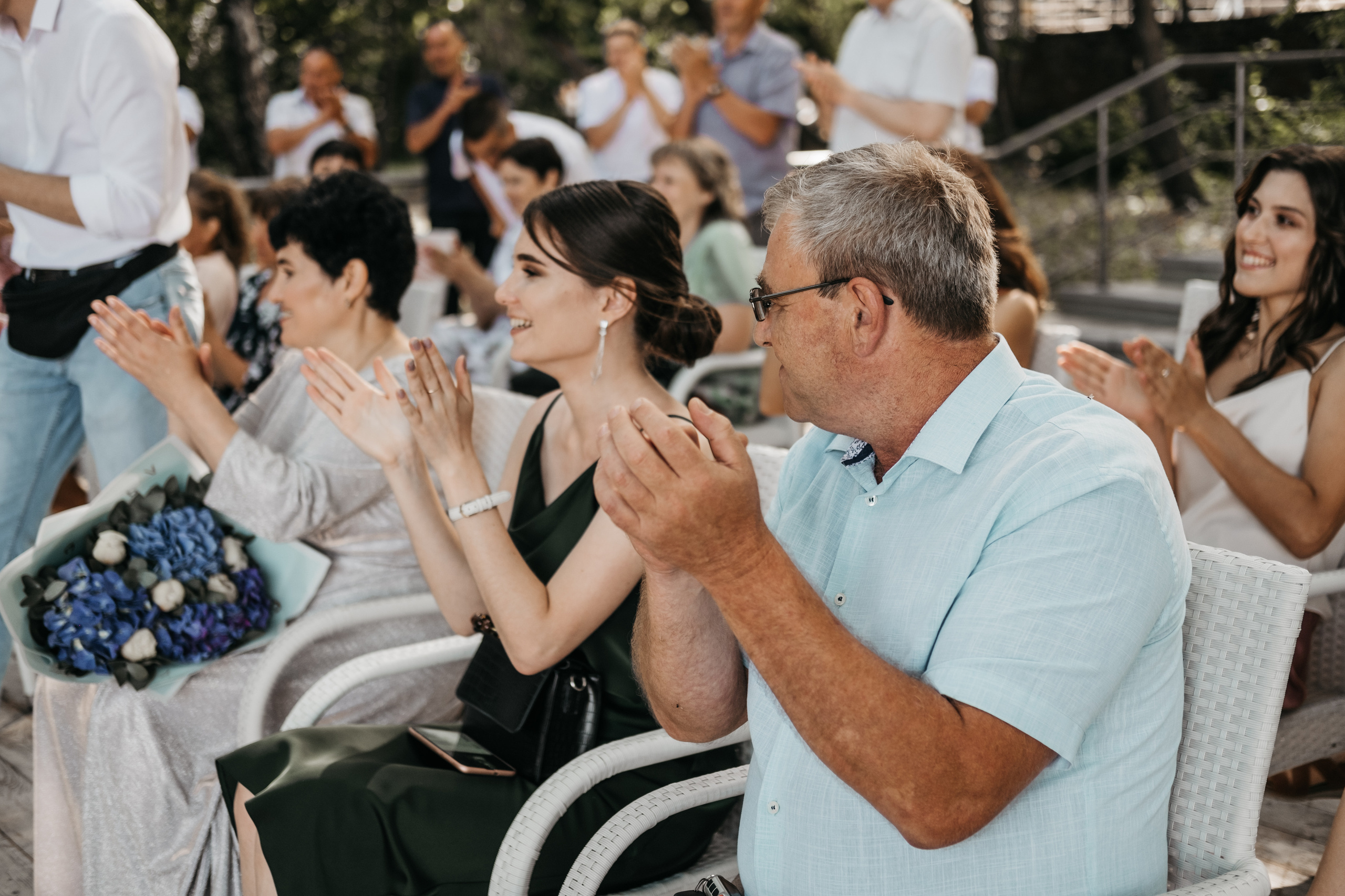 Гости свадьбы аплодируют на церемонии заключении брака.