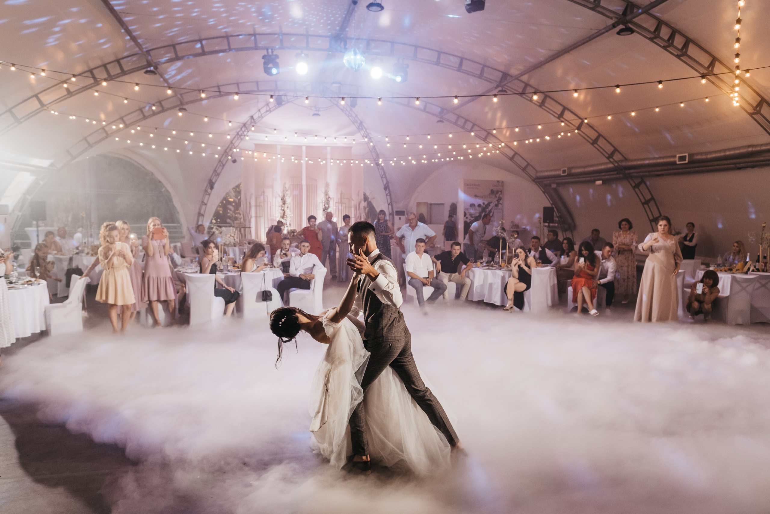 Супружеский танец под яркую подсветку в тумане.