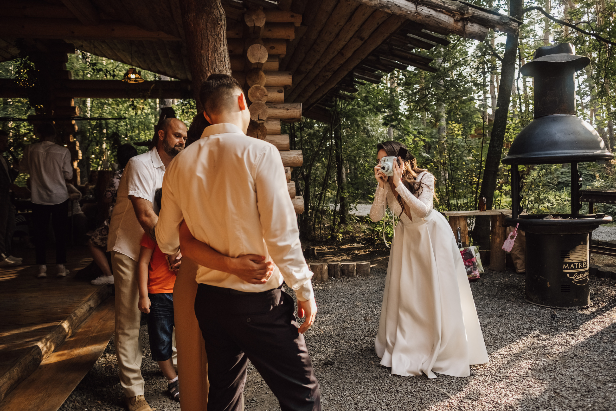 Невеста сама фотографирует гостей на пленочный фотоаппарат.