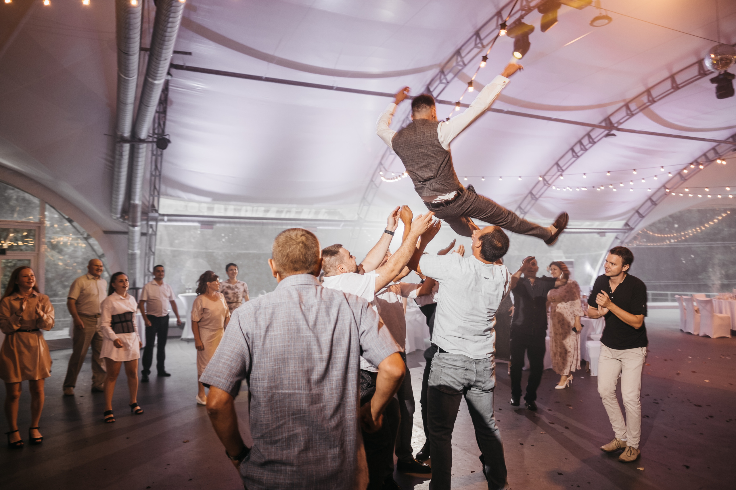 Весёлые гости подкидывают вверх жениха.