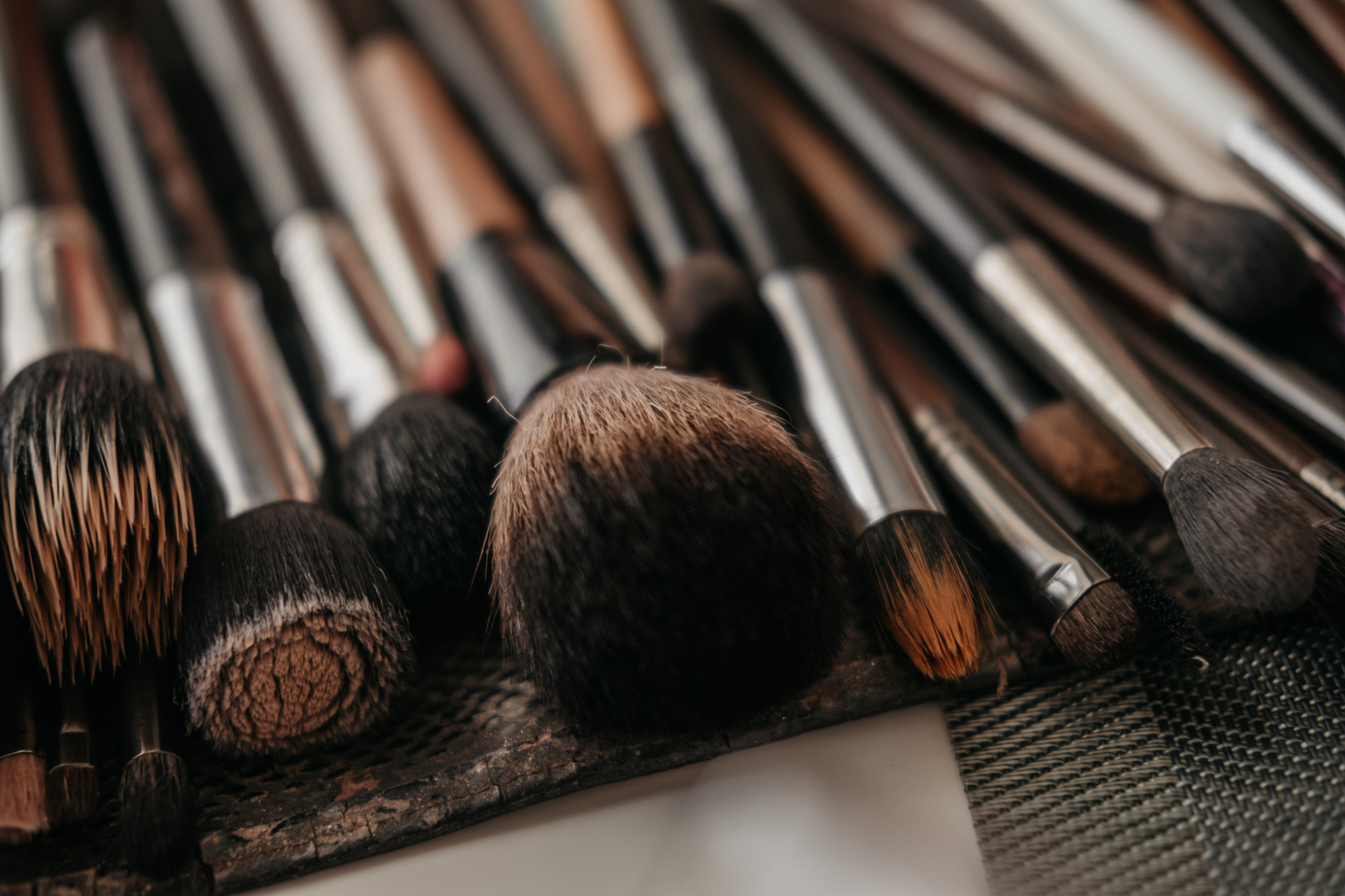 Набор макияжных кисточек лежит на столе.