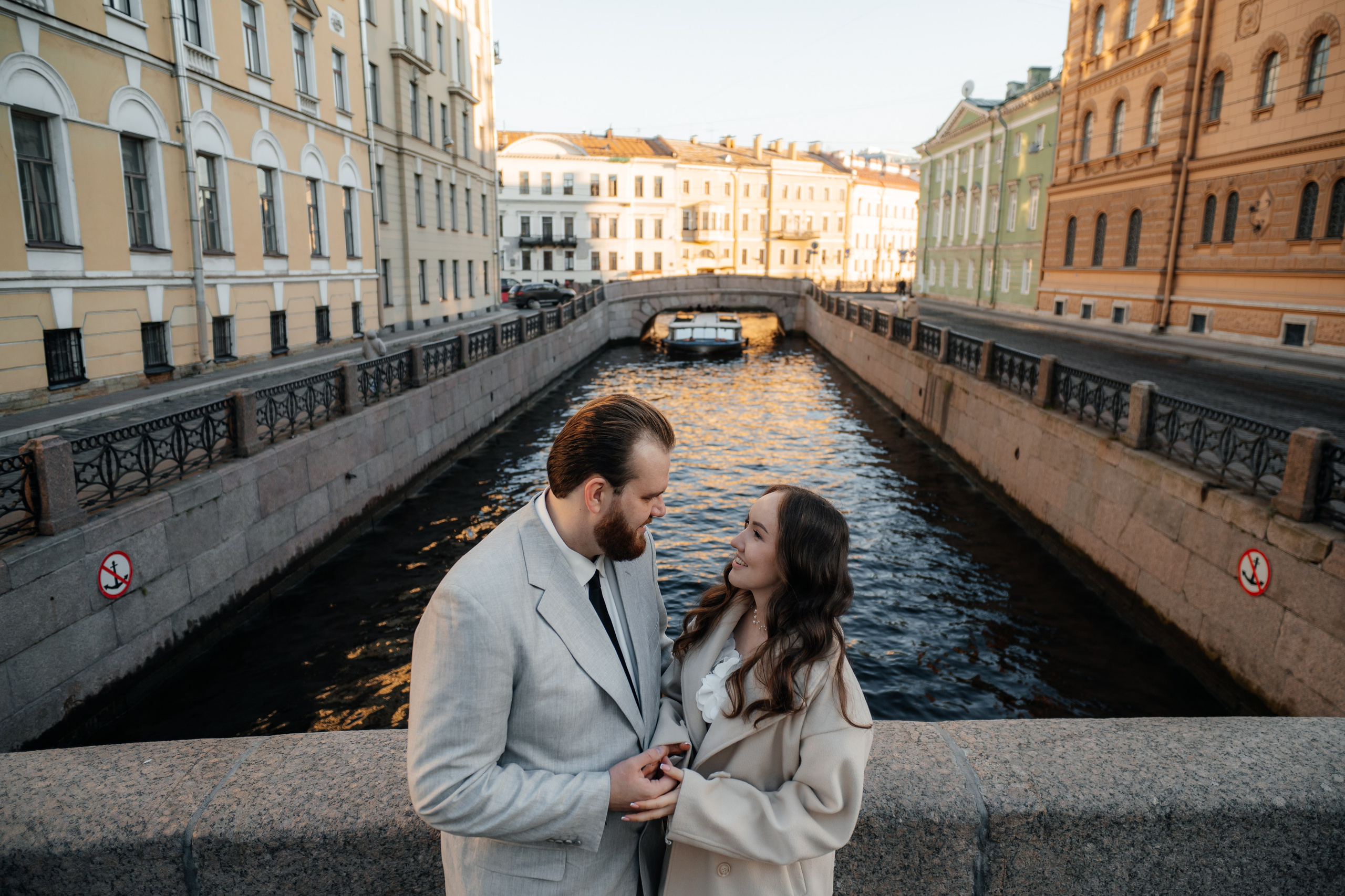 Свадебная фотосессия у Эрмитажа у Зимней канавки жених и невеста смотрят друг на друга на мосту