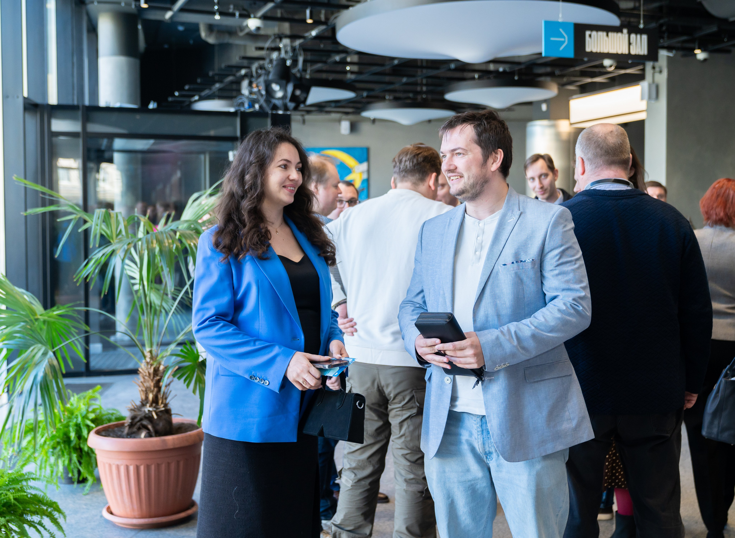 Деловое общение на мероприятии День местного самоуправления в Санкт-Петербурге. Женщина в ярком синем пиджаке и мужчина в светлом костюме. Фотограф Евгений Мальцев.