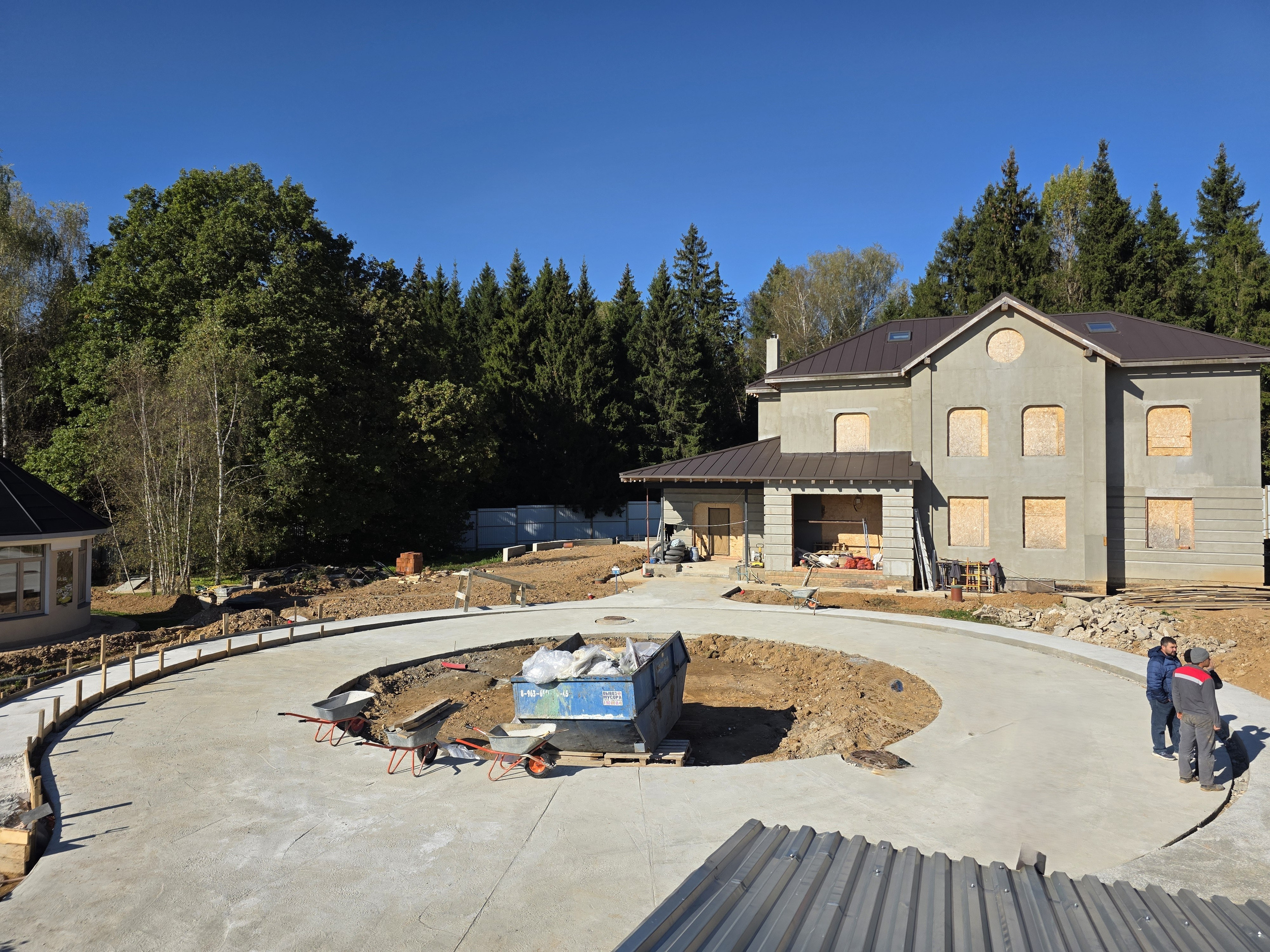 Общий вид участка с домом и бетонными дорожками — строительство в Подмосковье