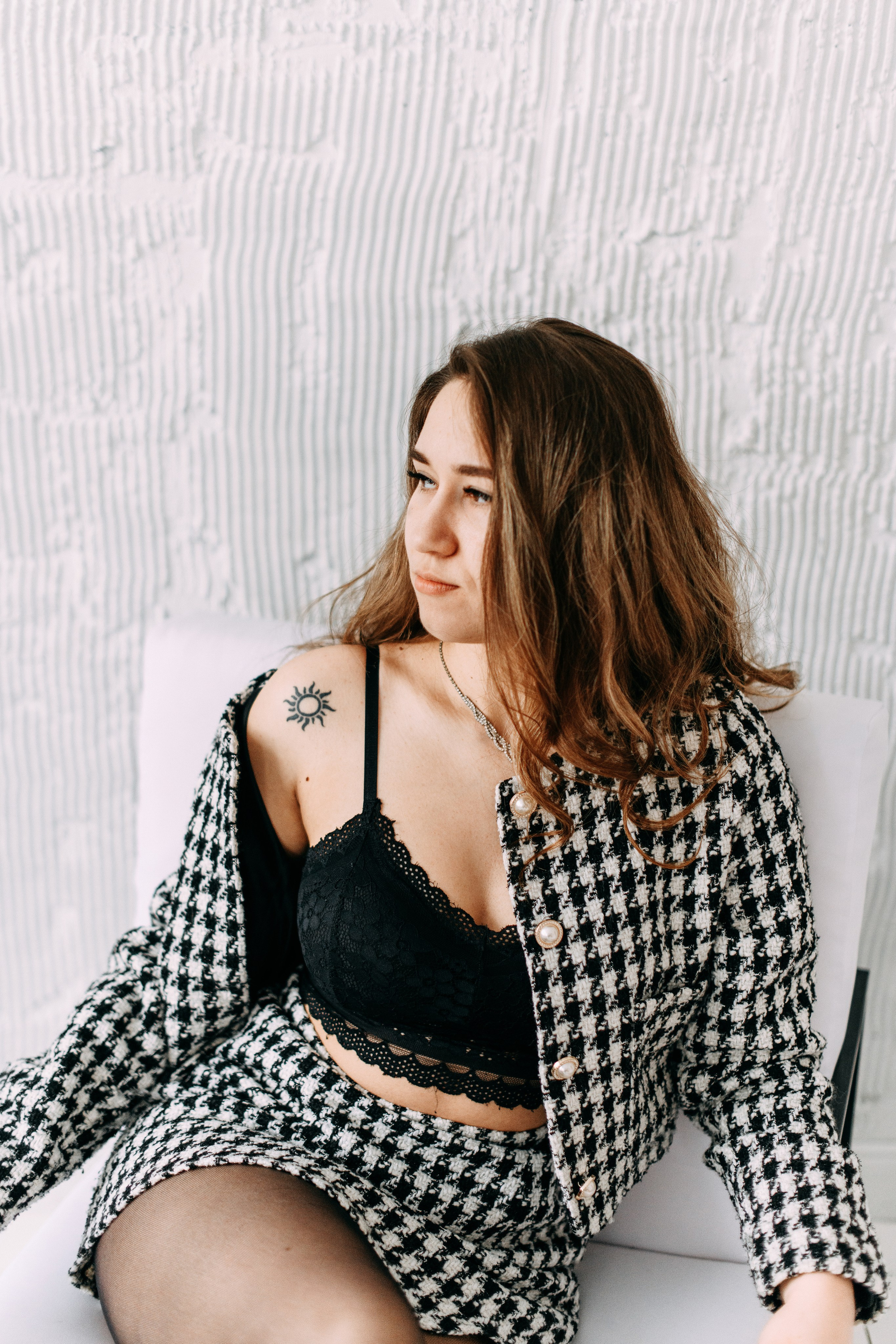 девушка в пиджаке и в топе сидит на кресле