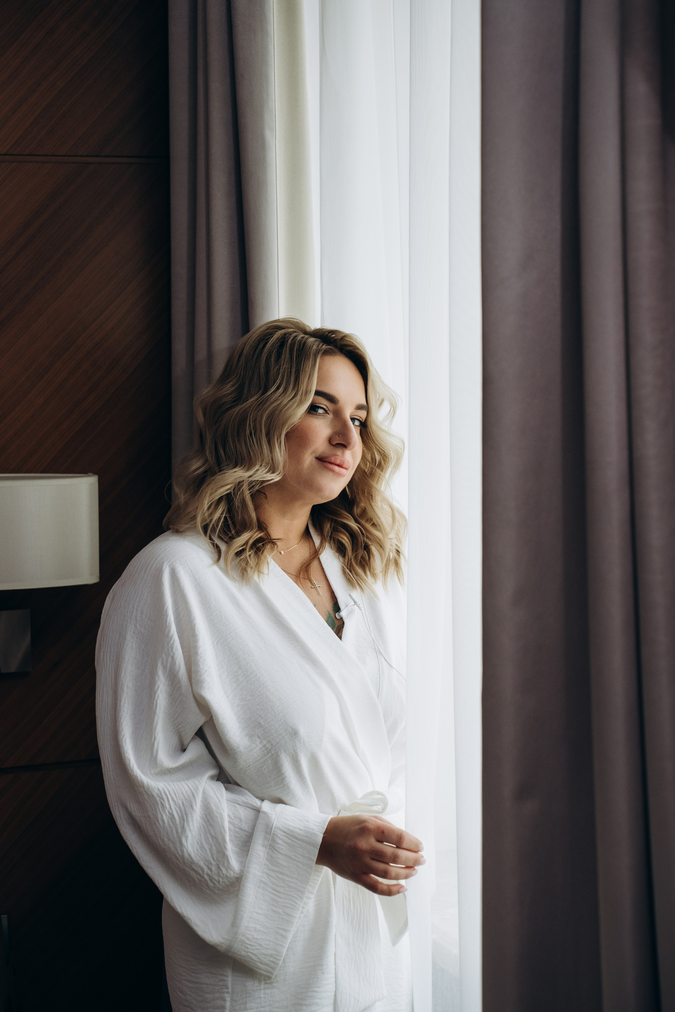 Невеста улыбается, держась за букет — эмоциональные моменты сборов, наполненные ожиданием и радостью.