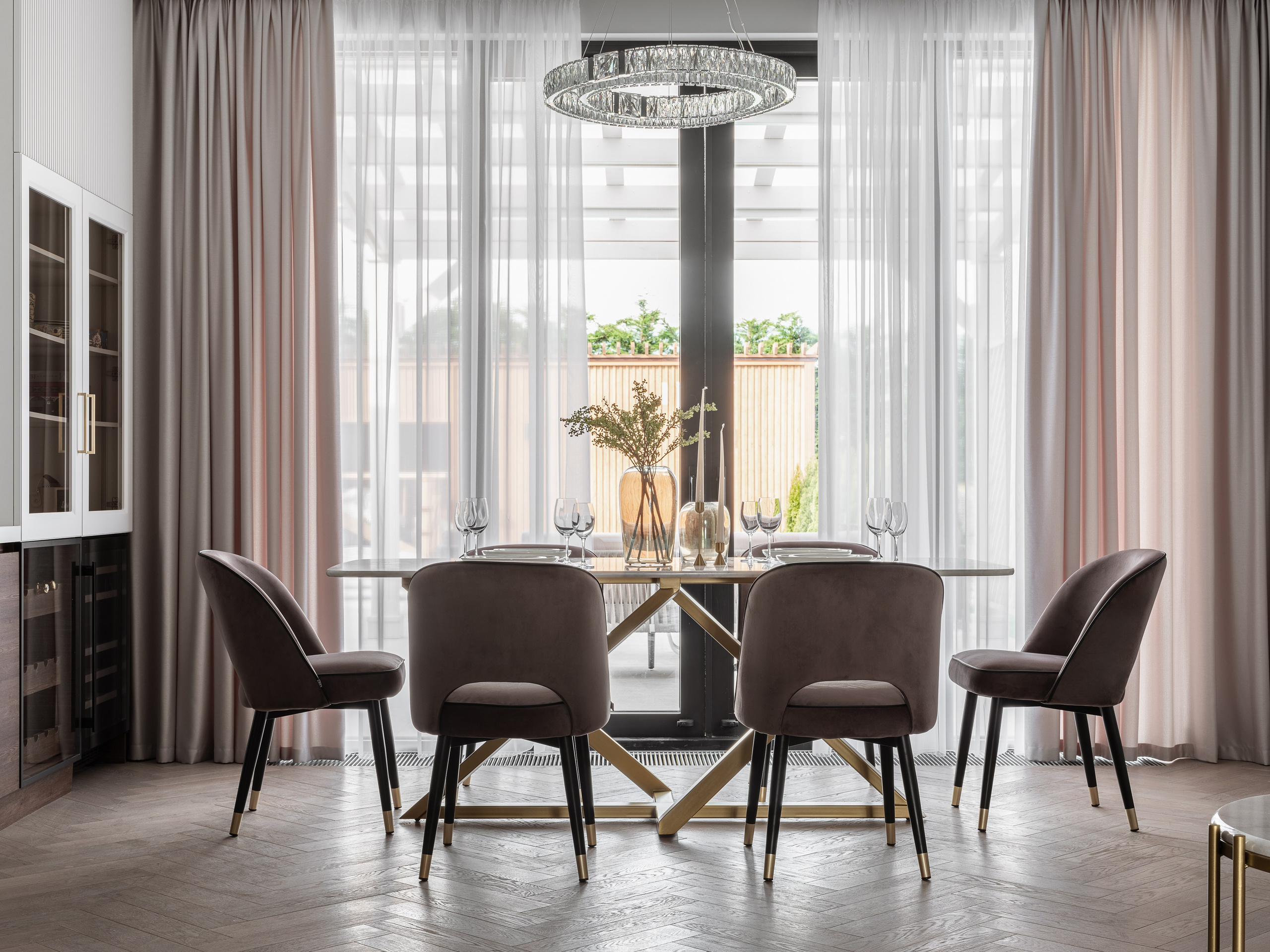 Просторная столовая с обеденным столом на золотом основании и бархатными стульями, оформленная в спокойной палитре. Панорамные окна и светлые шторы подчеркивают стиль, дизайнер Василисса Бачева, стилист Наталья Якушева, фото Сергей Денисенко.
