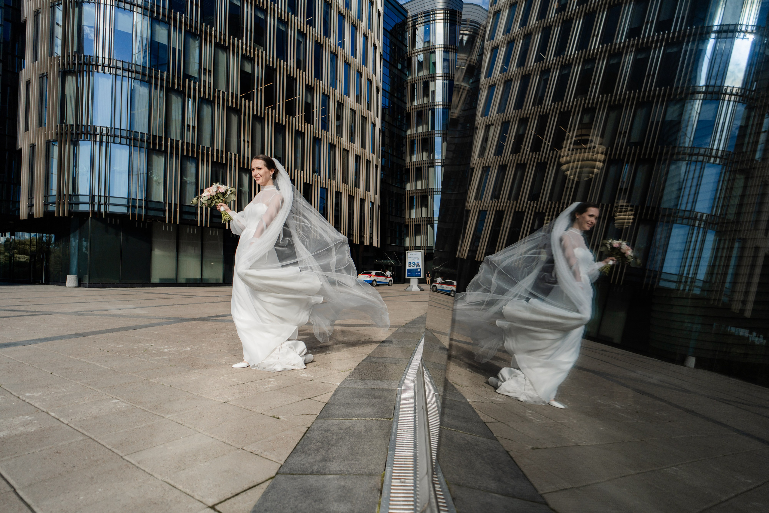 невеста на ветру идет около здания Банка Санкт-Петербург