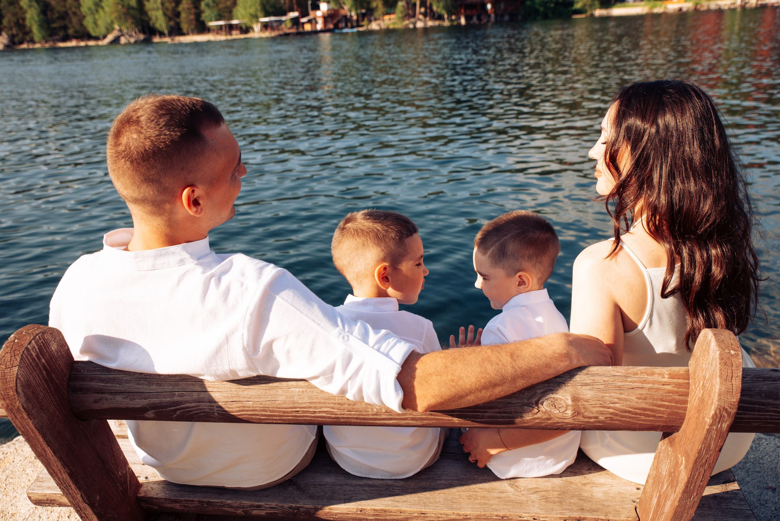 Семейная прогулка летом на берегу озера по пляжу