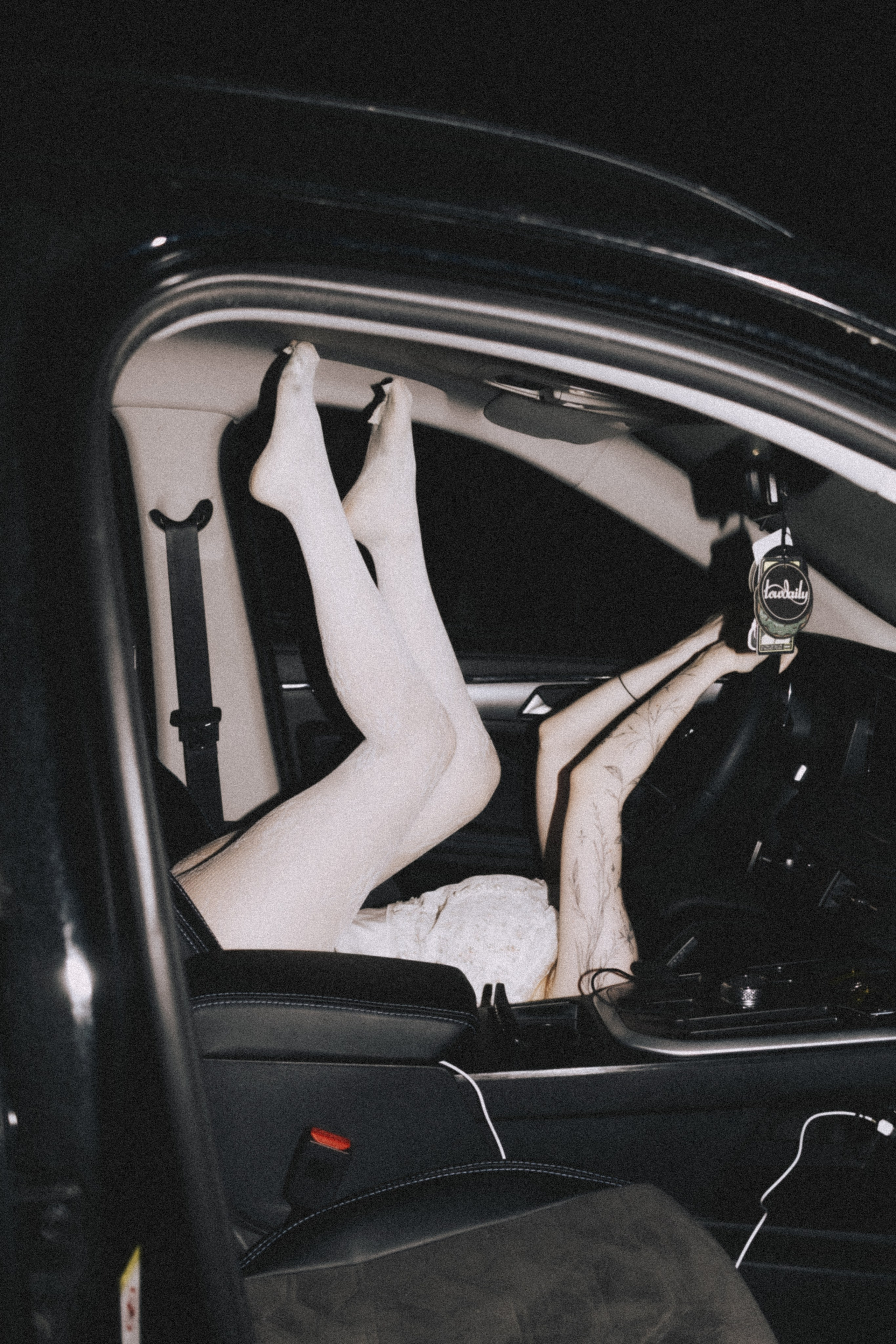 Ноги девушки в белых чулках и туфлях на руле машины, салон ночью. Уличная фотосессия в Пензе, Александра Овечкина
