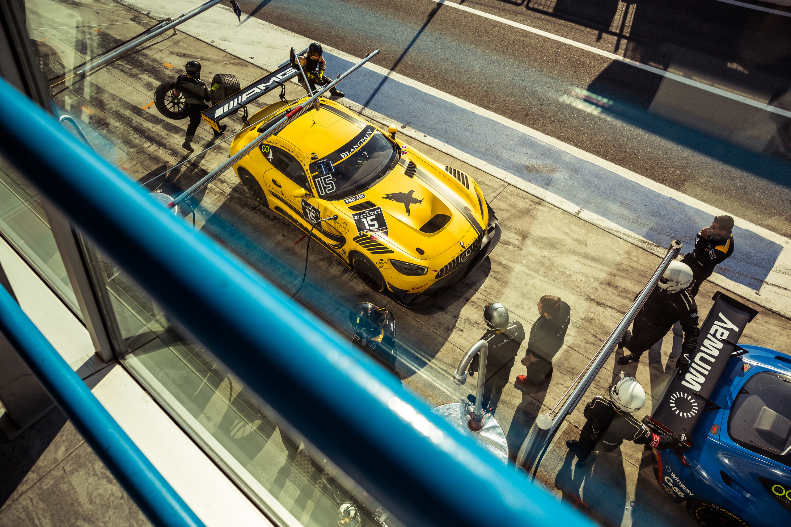 Желтый автомобиль Mercedes-Benz на питлейне на гоночной трассе