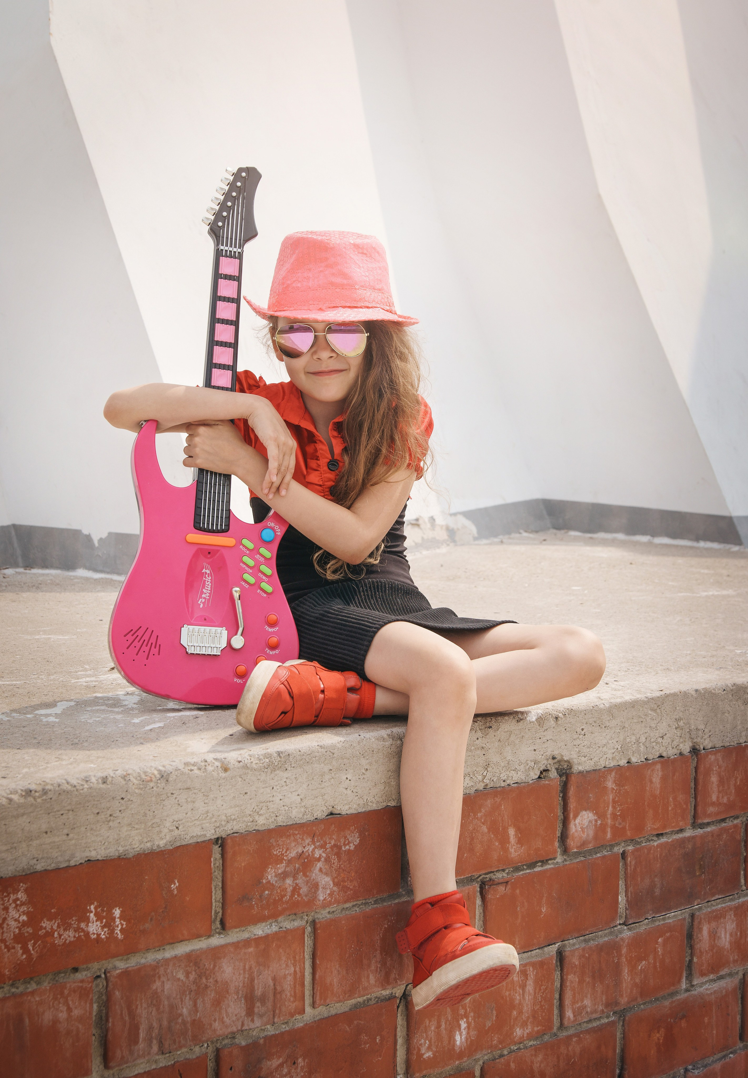 Детская фотосессия летом - девочка сидя с гитарой