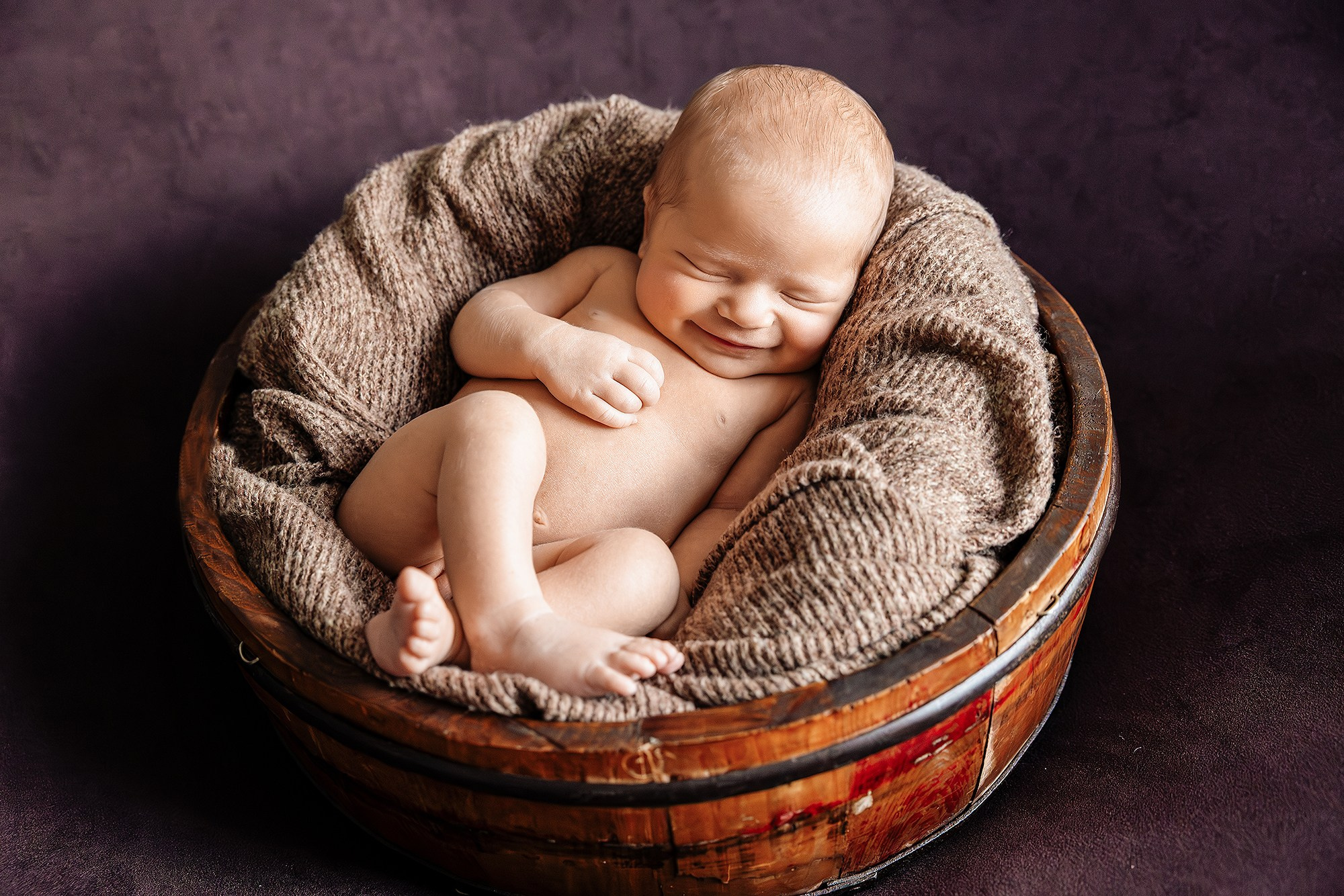 Малыш улыбается на фотографии ньюборн.