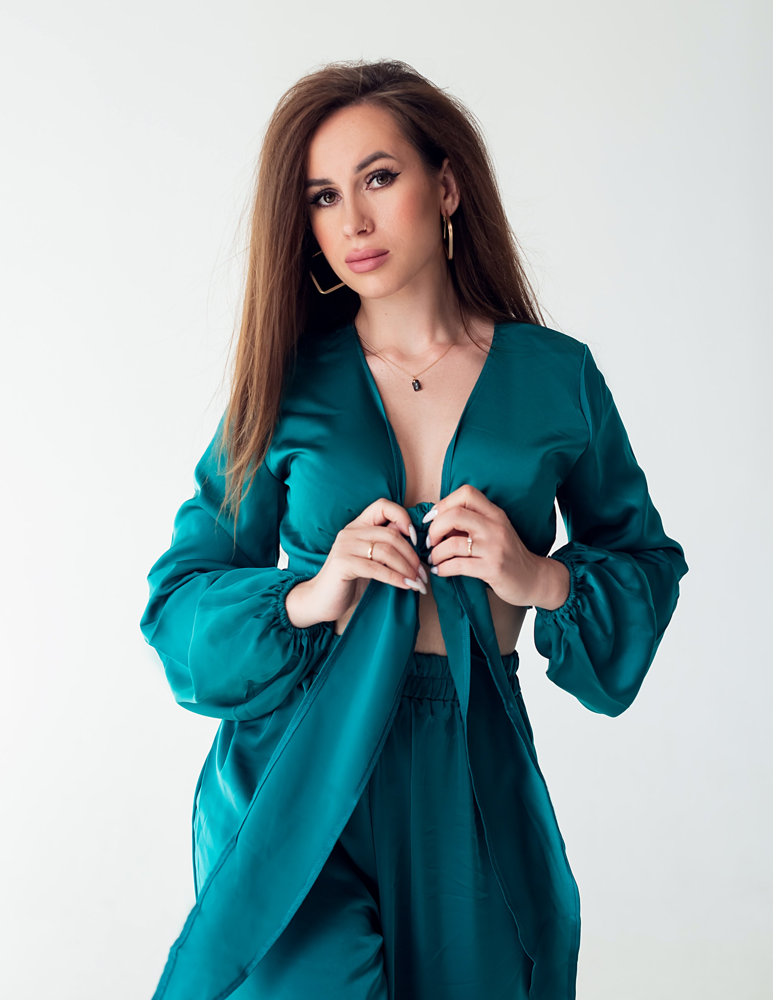 Девушка в изумрудном костюме пижамного стиля.