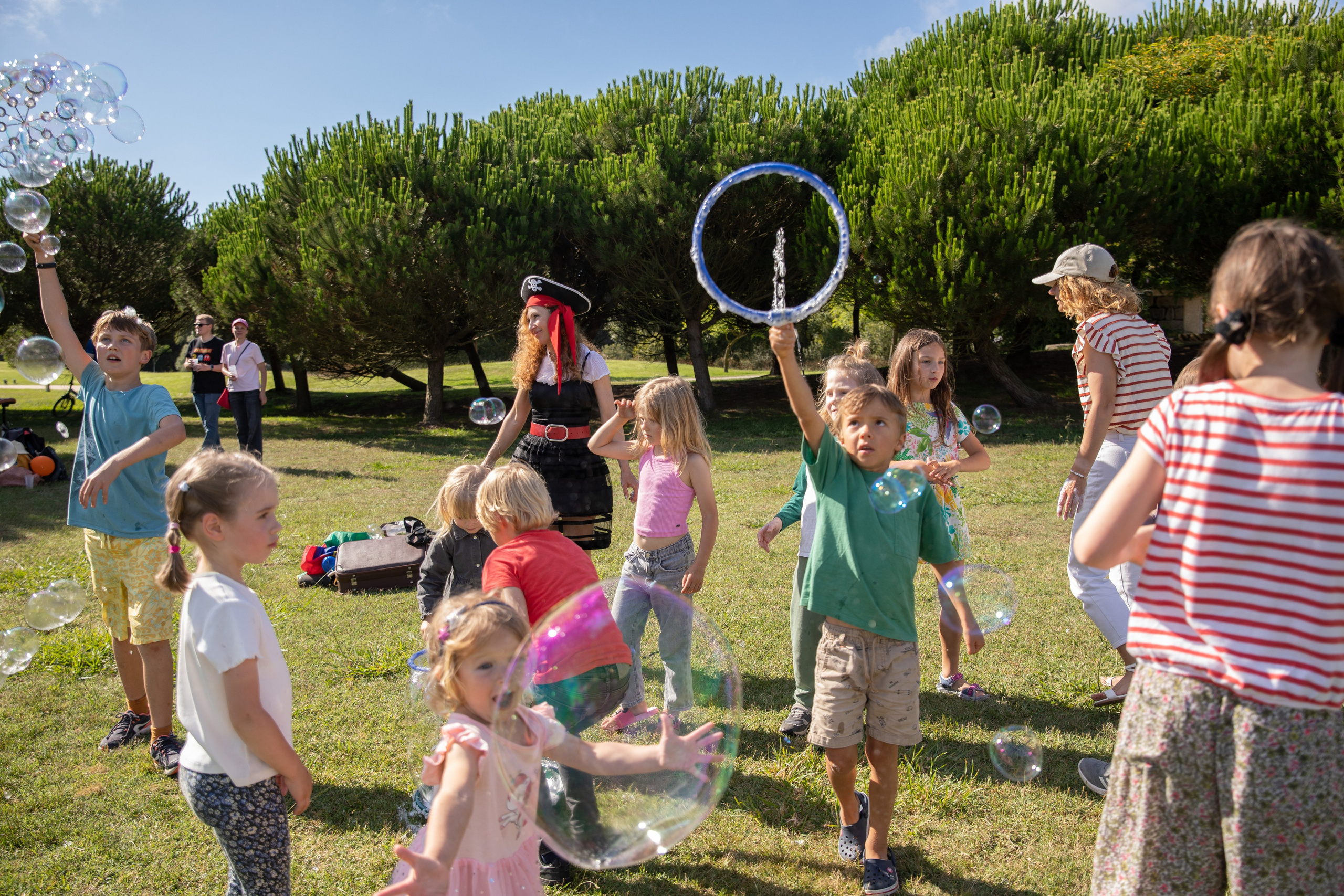 Park birthday photo shoot with kids having fun and soap bubbles in the air