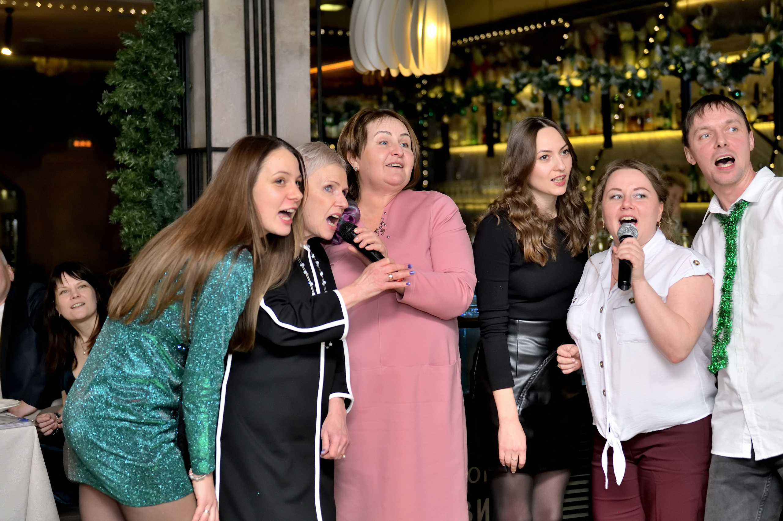 "Сотрудники компании поют на новогоднем корпоративе".