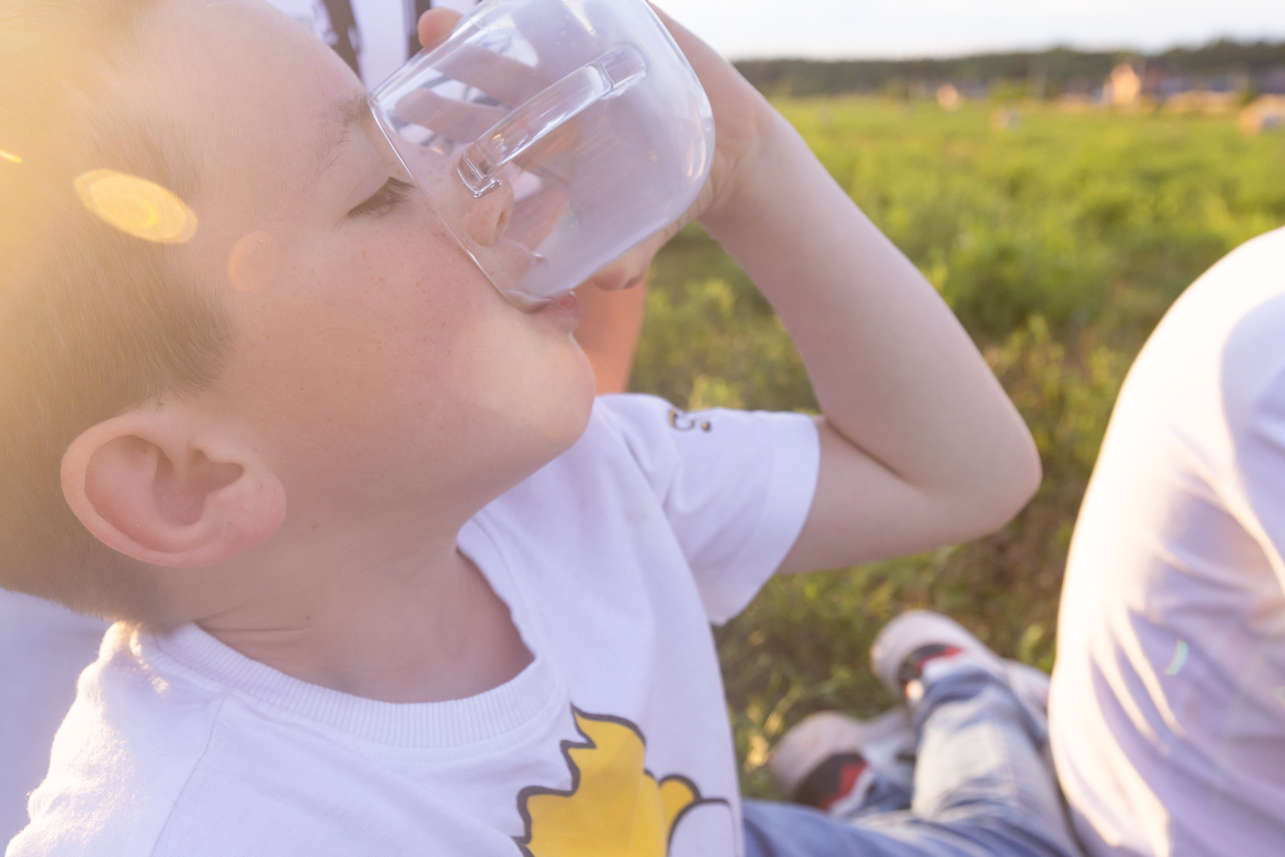 Мальчик пьет из стеклянной кружки молоко