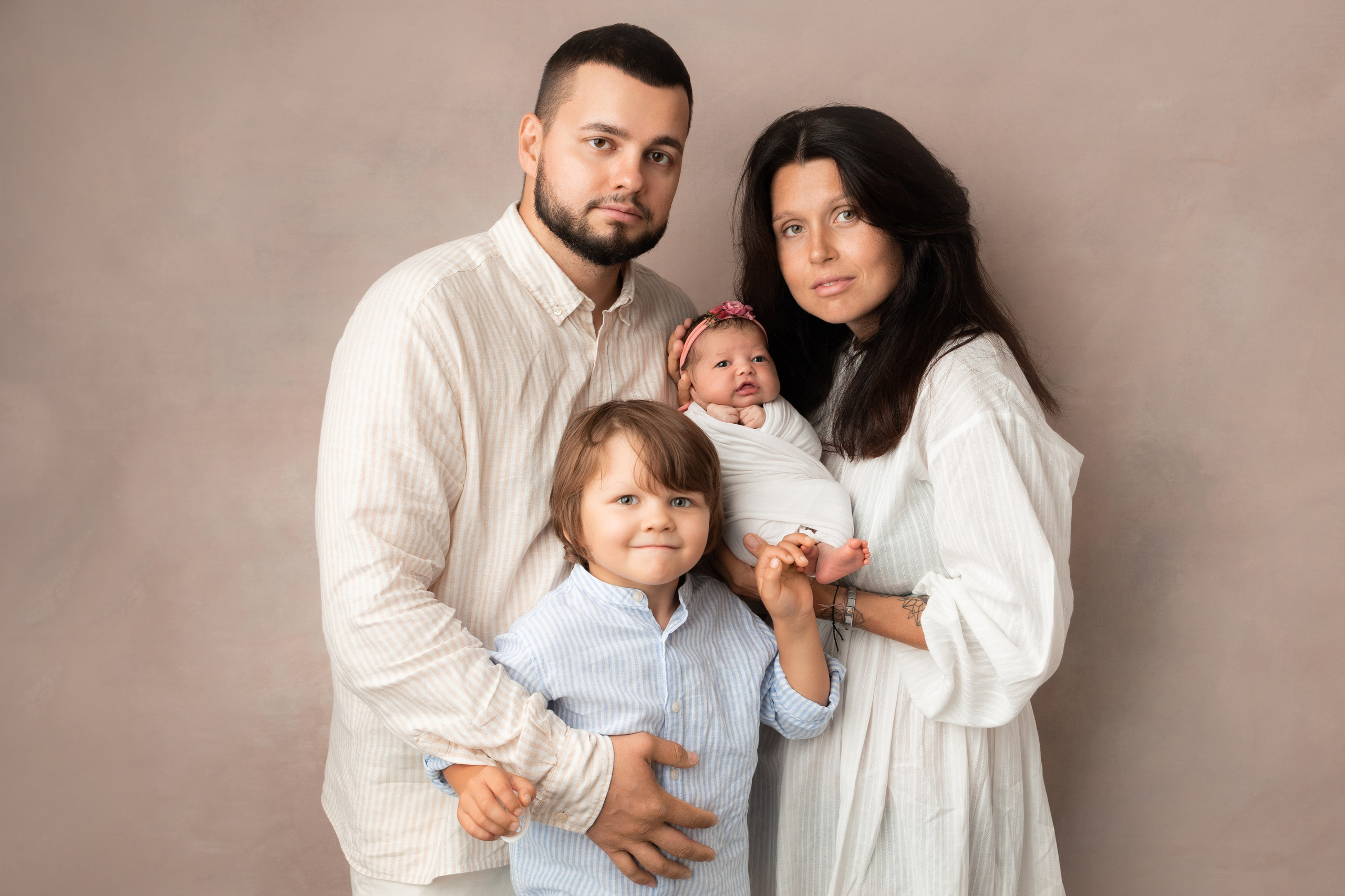 семья с новорожденным и старшим братом на светлом фоне 