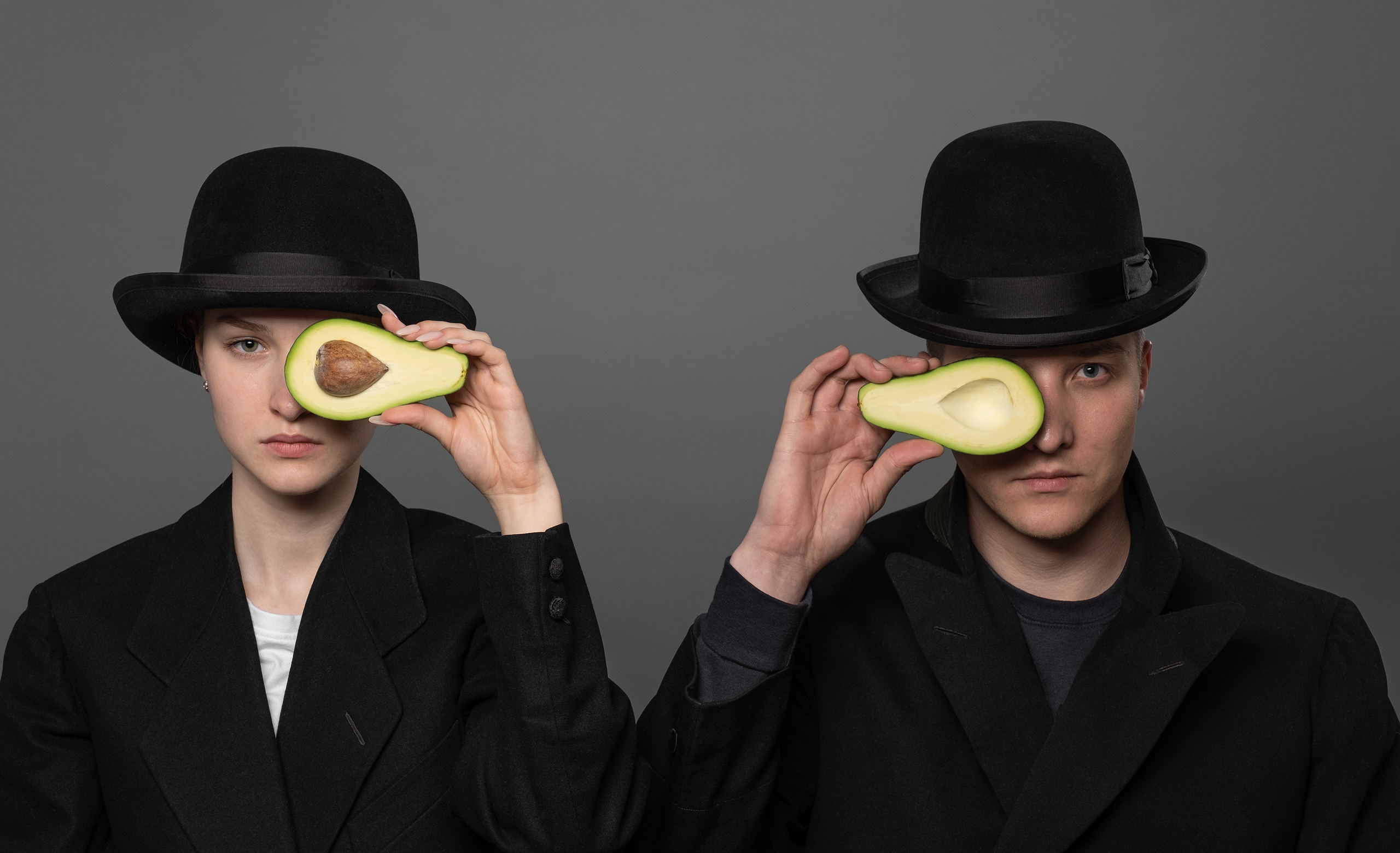 Девушка и юноша с авакадо и в котелках в стиле художника Рене Магритт.