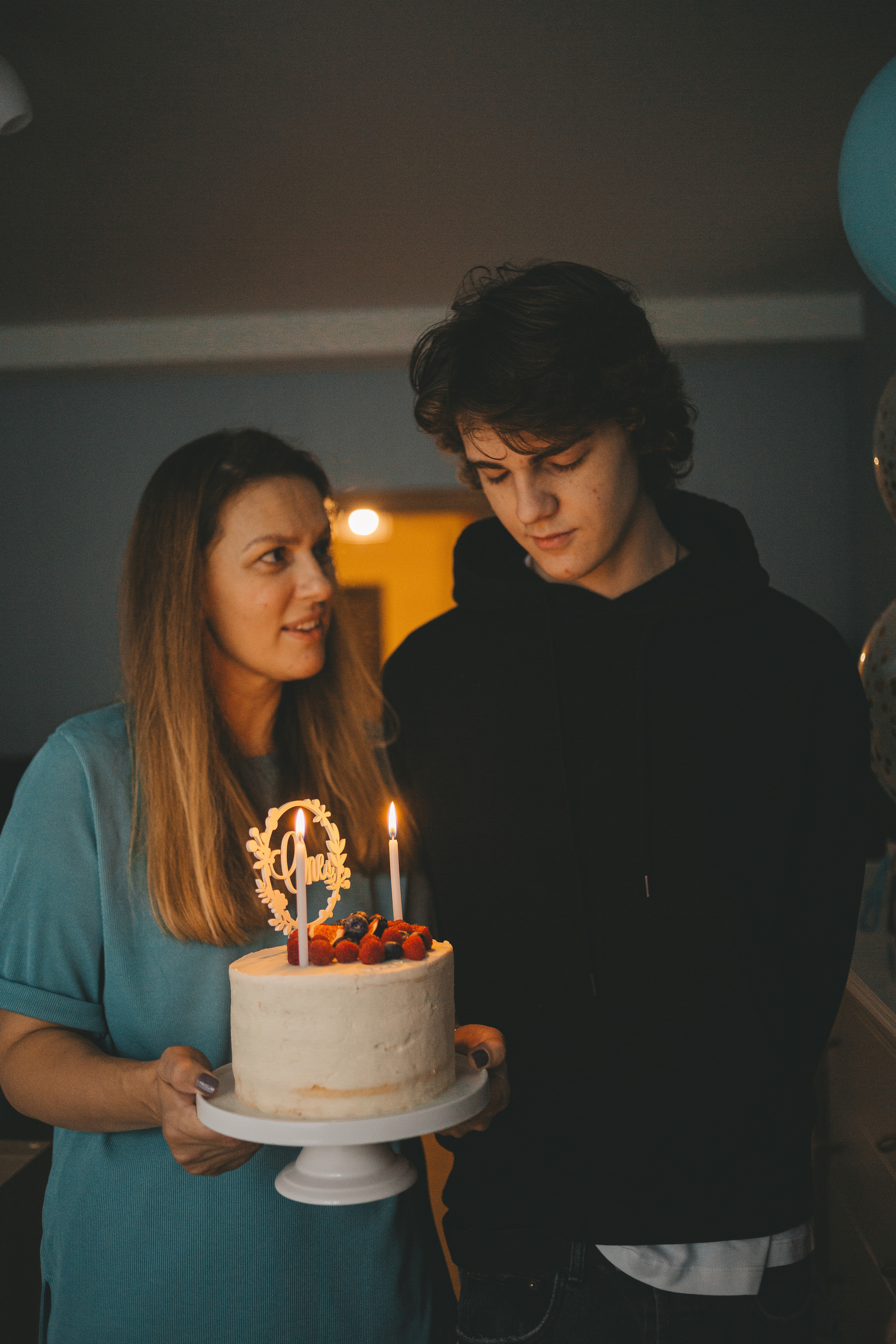 Старший сын загадывет желание, мужчина загадывает, молодой парень в черной кофте