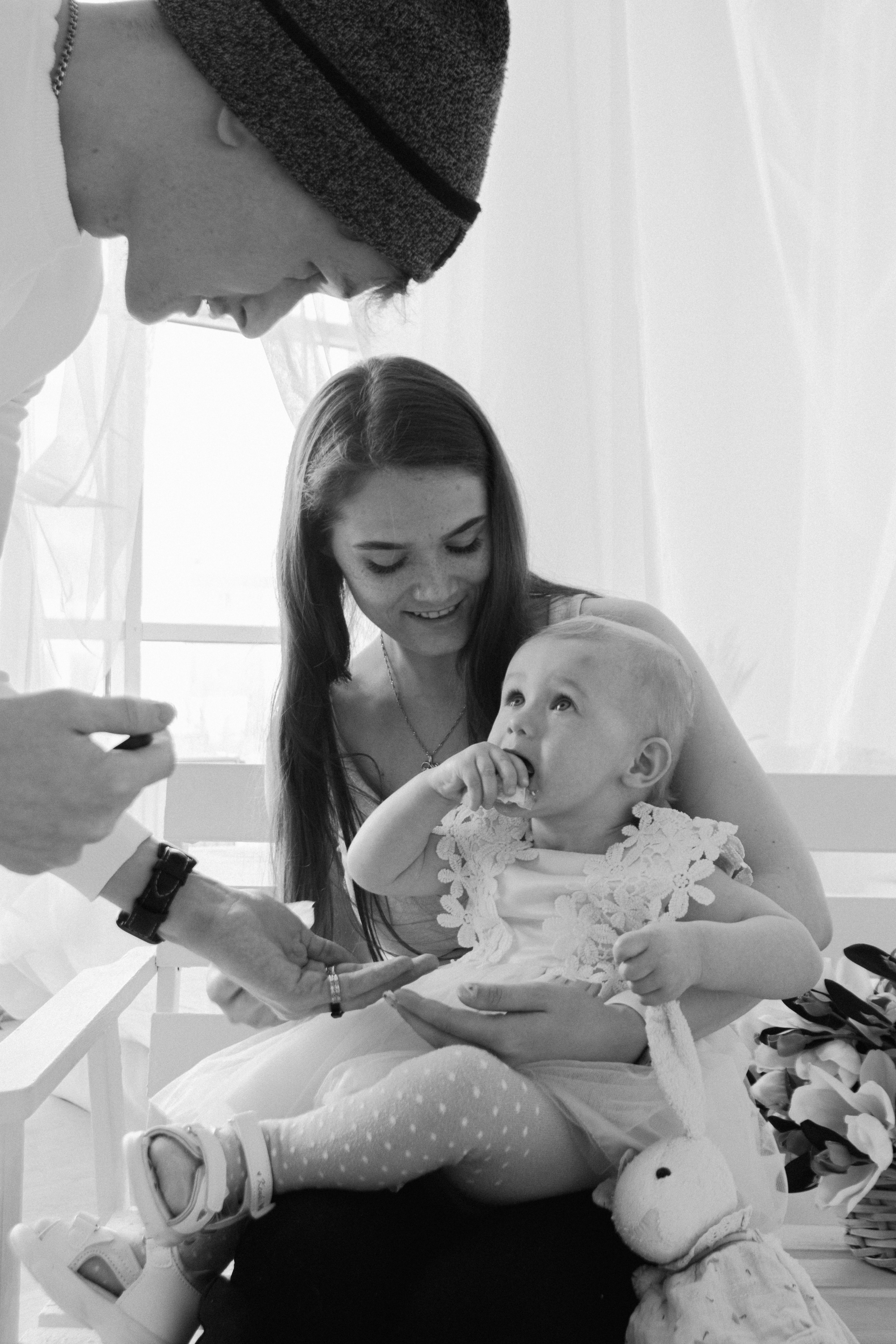 Папа с мамой вытирают руки дочке которая испачкалась в именинном торте