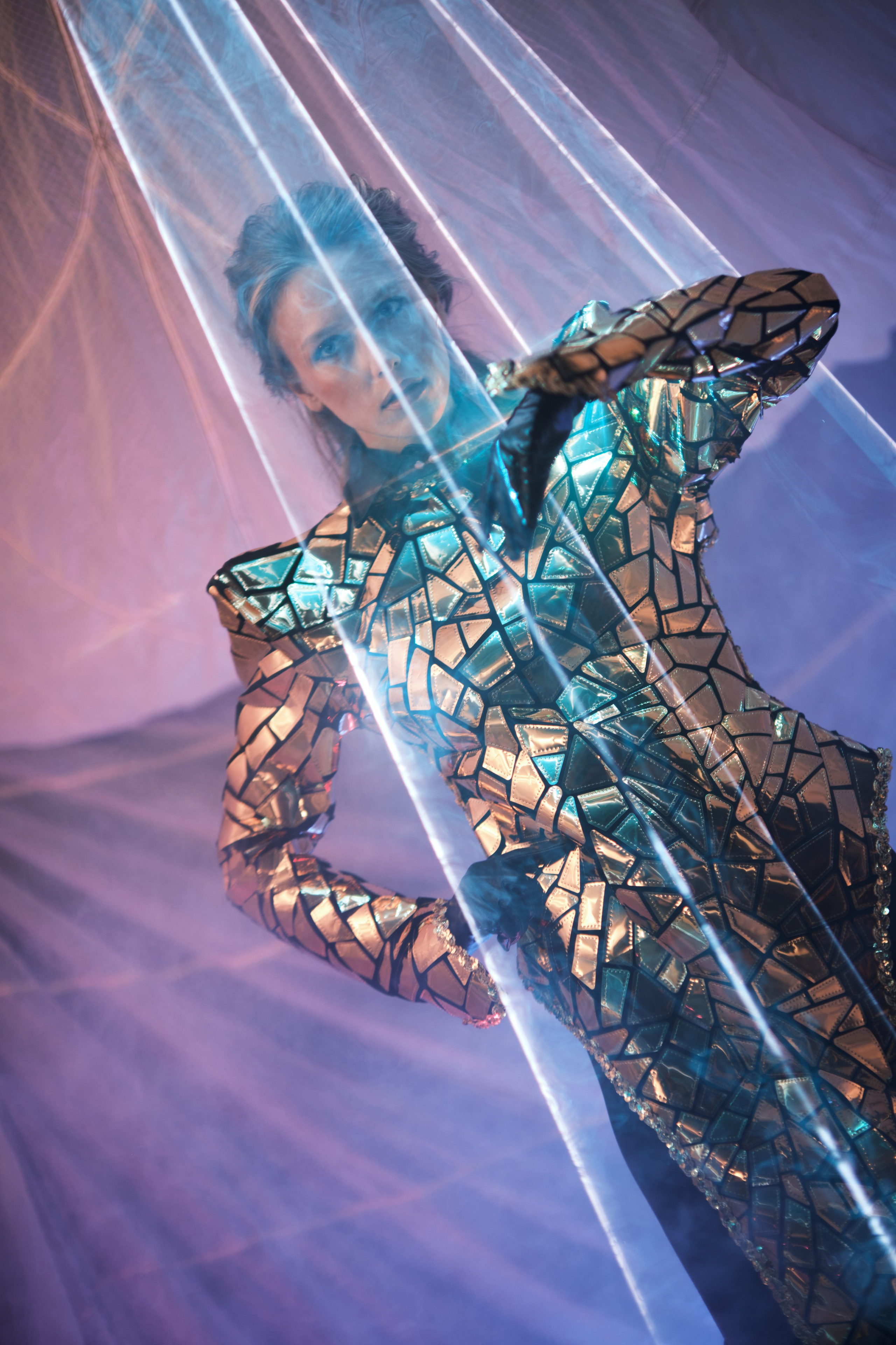 Фотосессия в стиле футуристической моды девушка в зеркальном костюме с отражения лазера