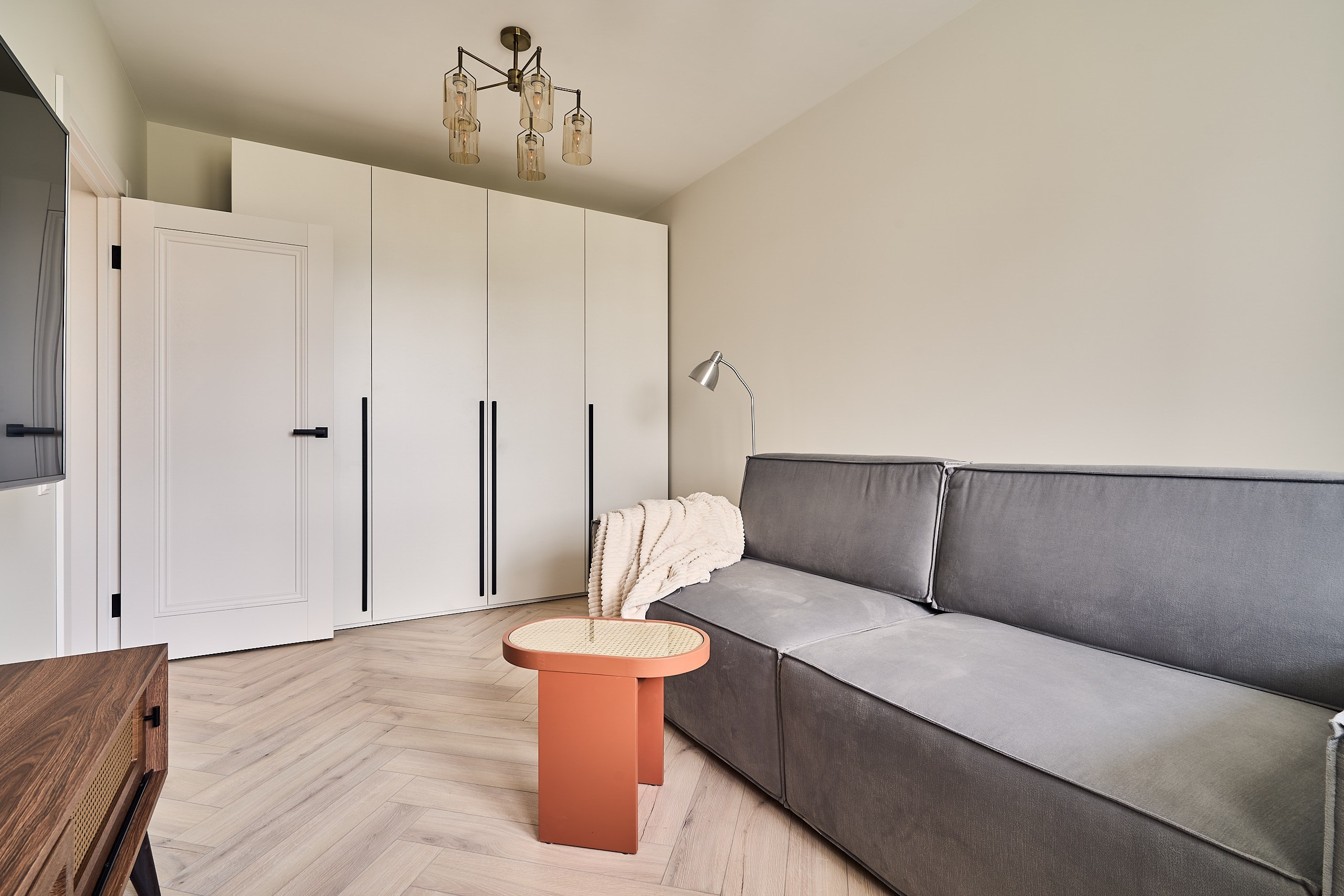 Интерьерная фотография с диваном, журнальным столиком и шкафом купе в гостиной двухкомнатной квартиры в СЗАО Москвы