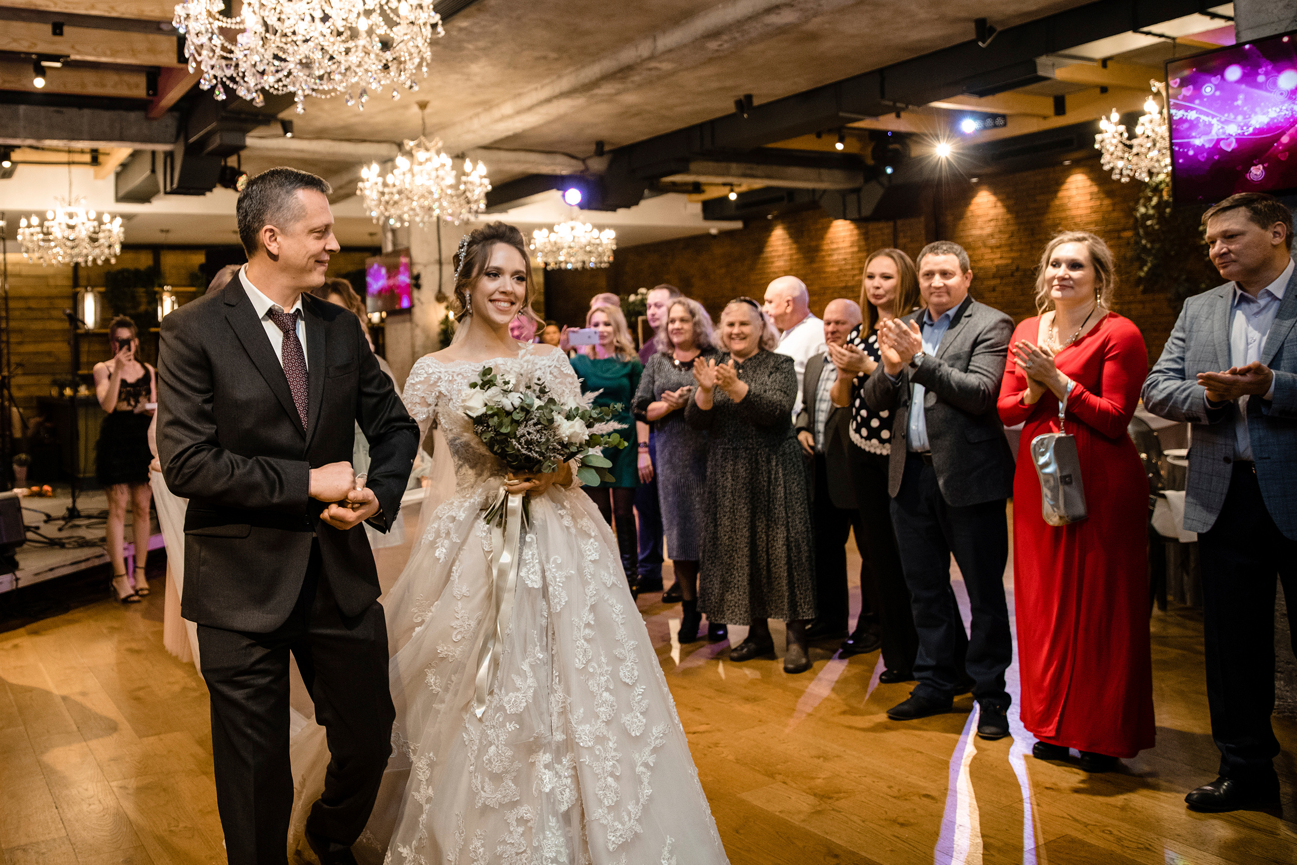 Невеста со своим отцом идут к арке