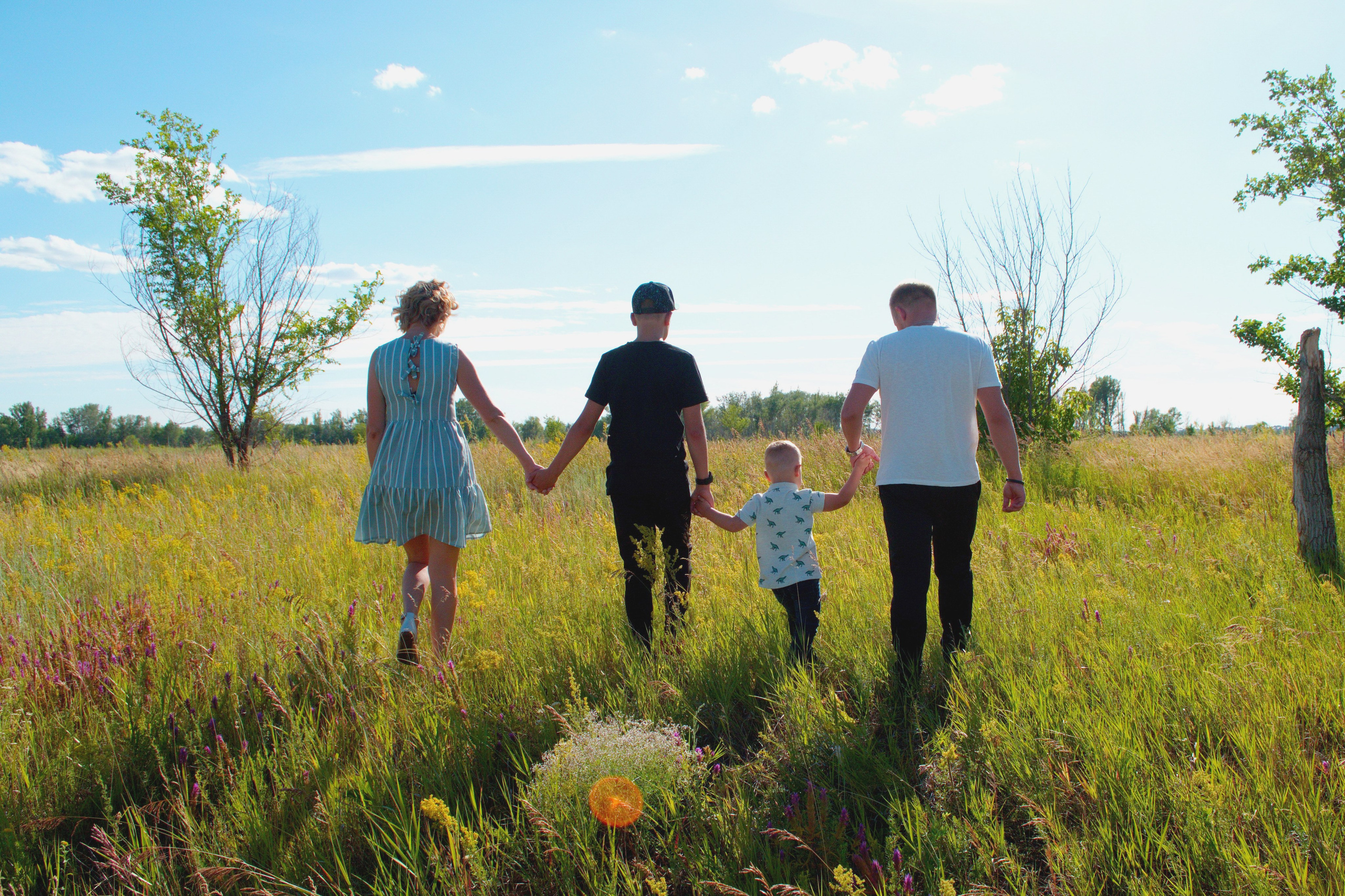 Семья из 4-х человек, взявшись за руки, уходит вдаль.