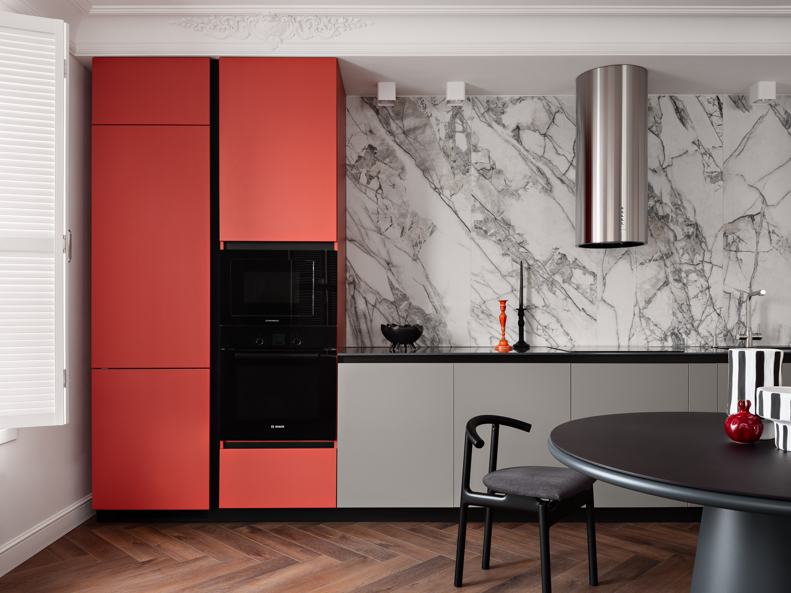 Интерьер кухни с яркими красными фасадами шкафов, встроенной техникой Bosch и мраморным фартуком, создающим контраст. Дизайн: Антон Логинов, стилизация: Алёна Мощенская, фотография: Сергей Денисенко.