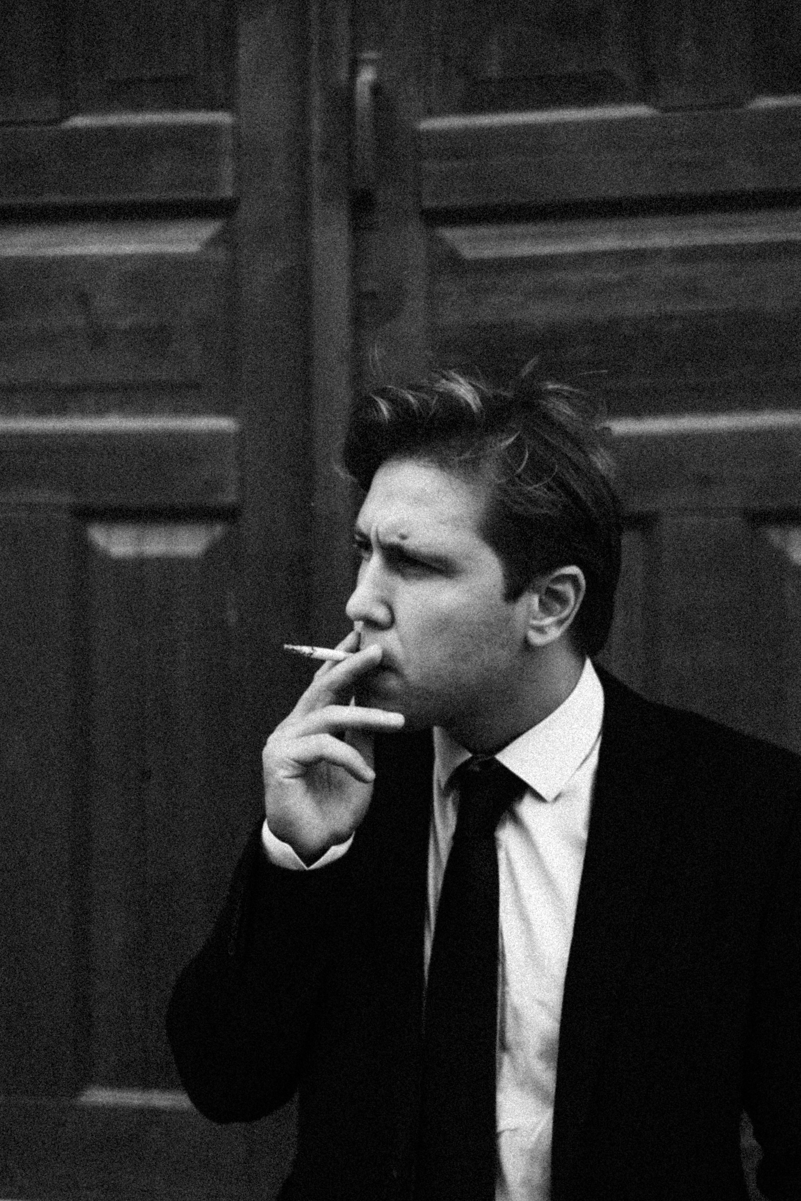 Мужчина затягивается сигаретой в ч/б