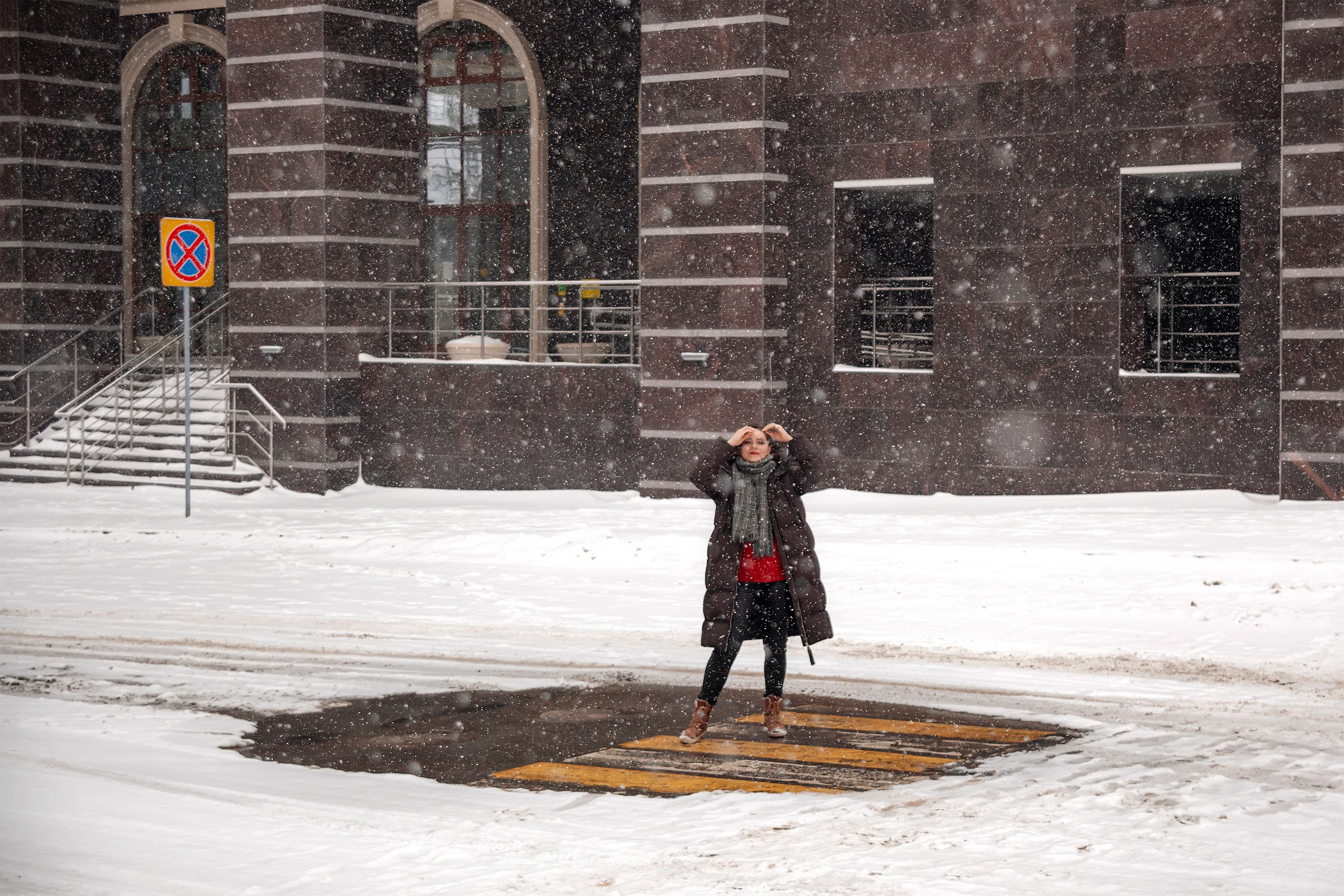 Девушка позирует на фоне большого здания