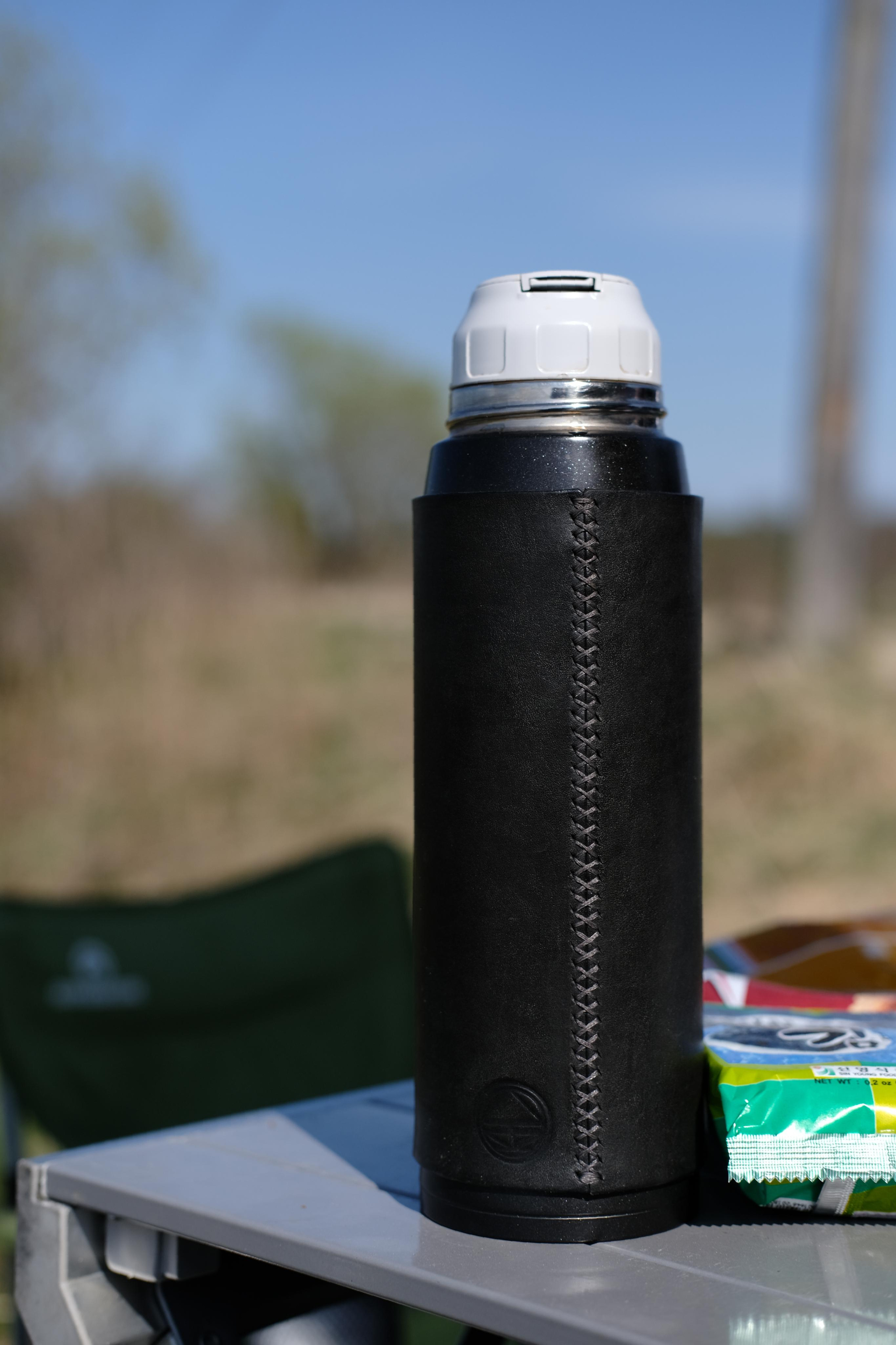 Cross-stitched thermos case made of 2 mm black leather, covered with finish gloss after six month of use.