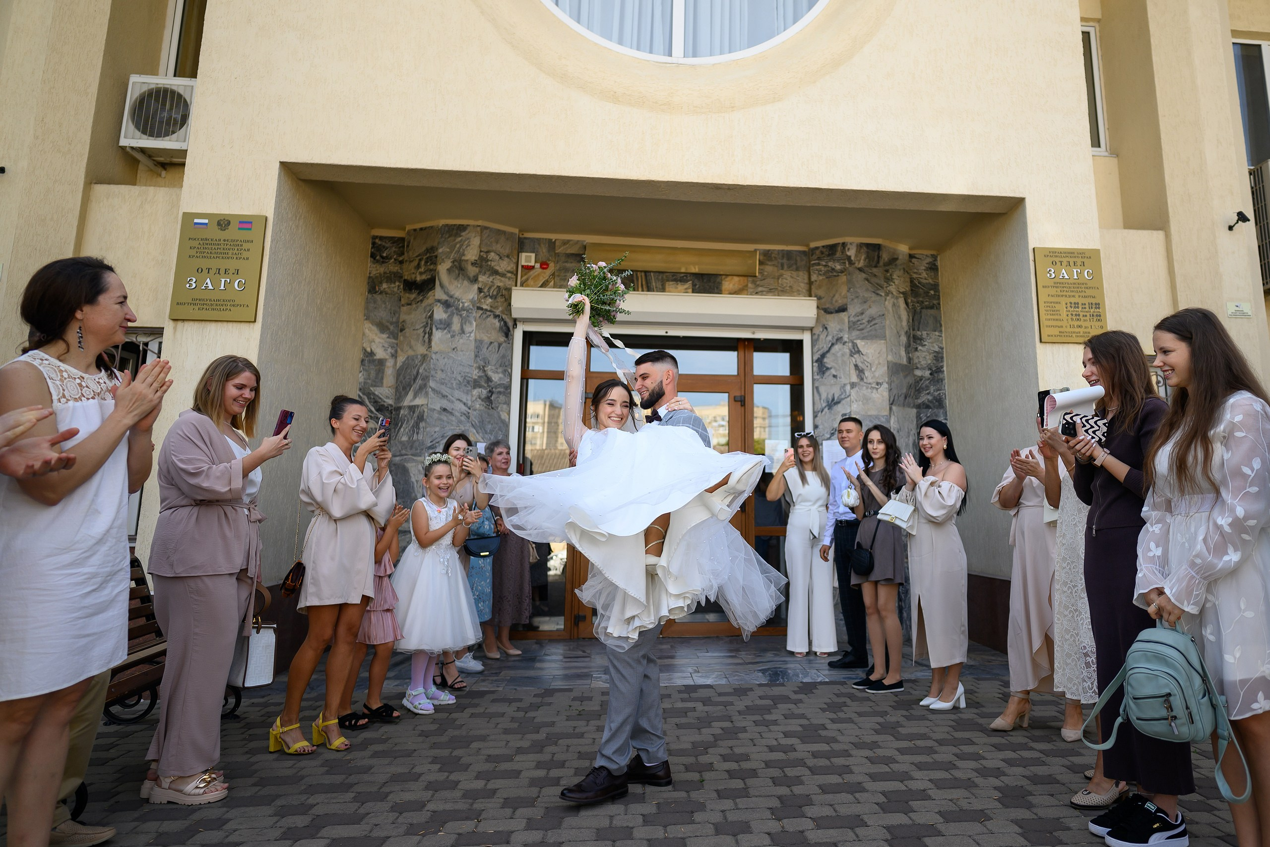 Молодожены выходят из ЗАГСа в Краснодаре.