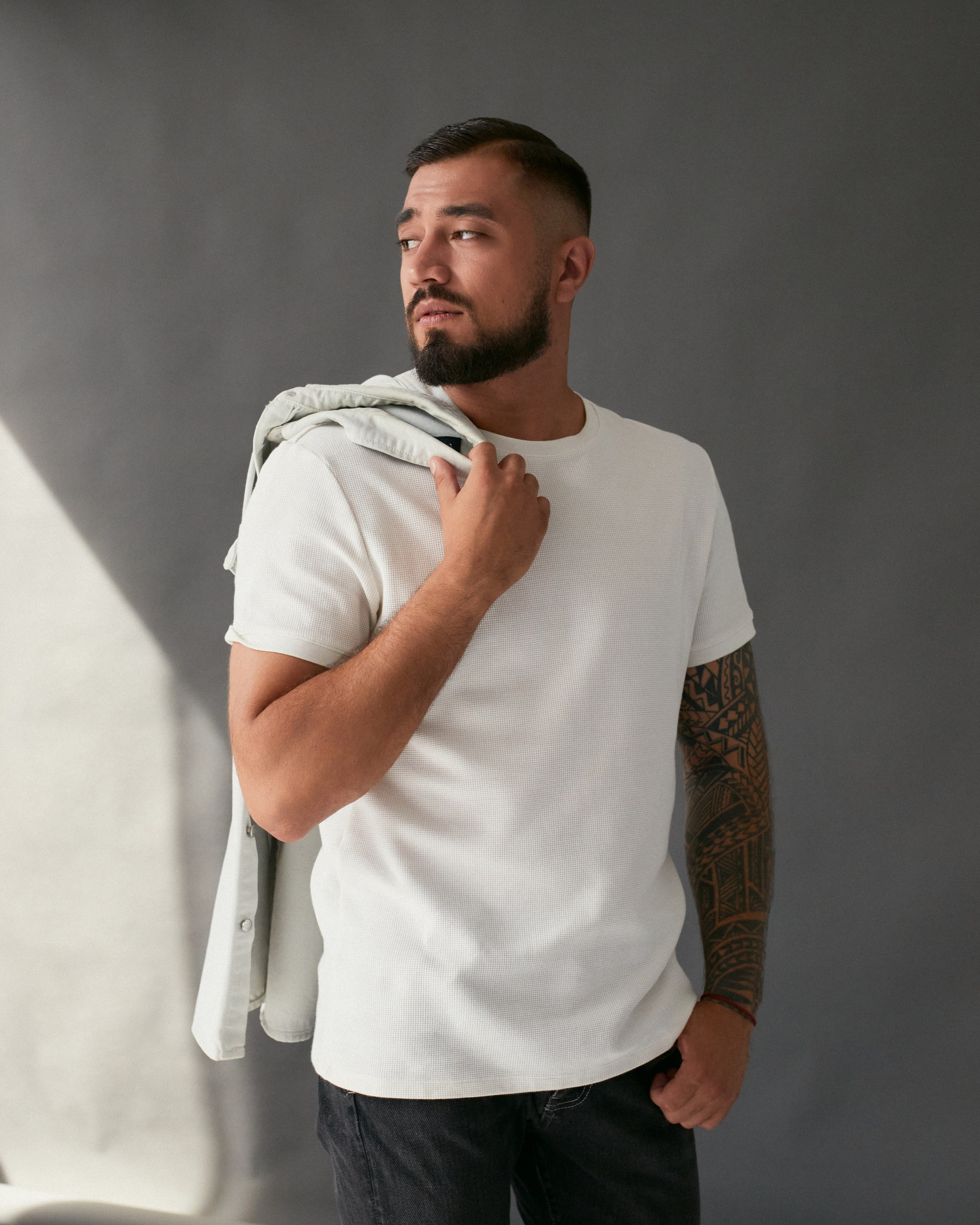 Мужчина с бородой в белой футболке